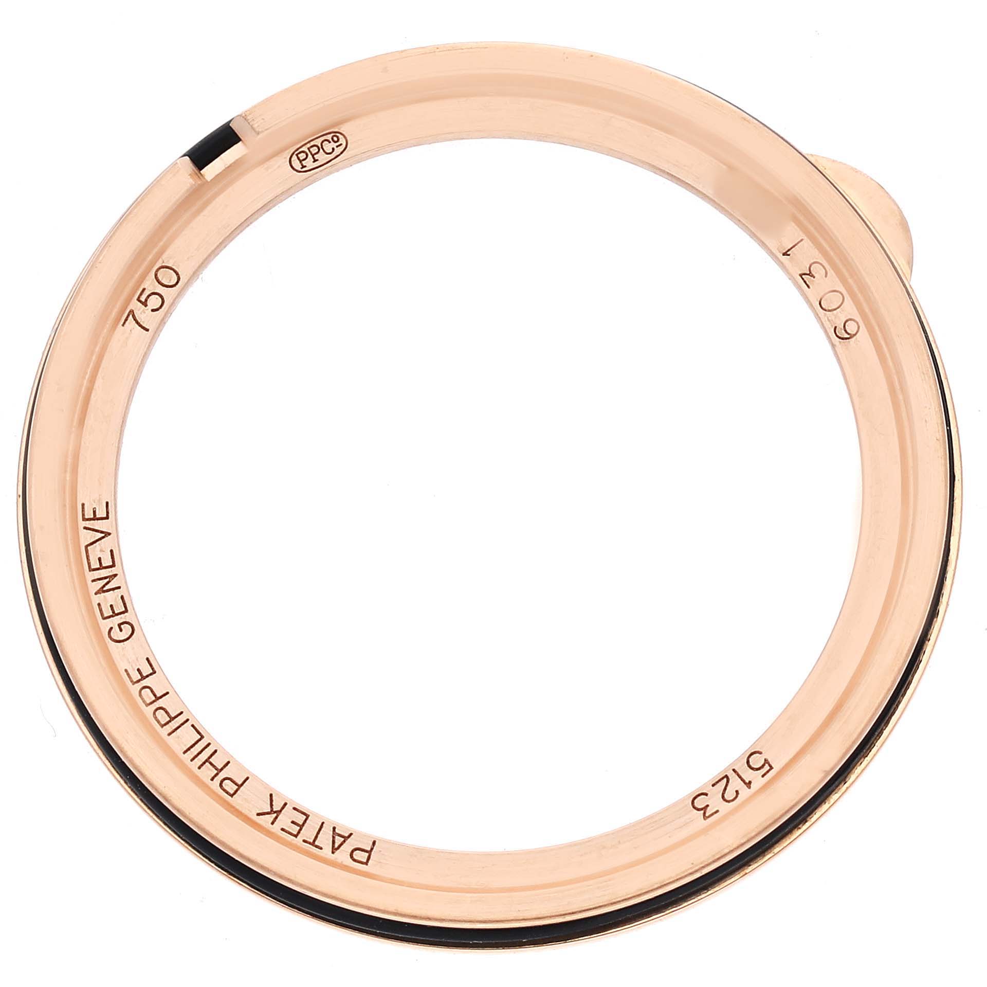 The image shows the bezel of a Patek Philippe Calatrava 5123R-001 Men
s Rose Gold Silver Dial 5123R-001 Men
s Rose Gold Silver Dial watch from a top-down angle, highlighting engravings and hallmark details.