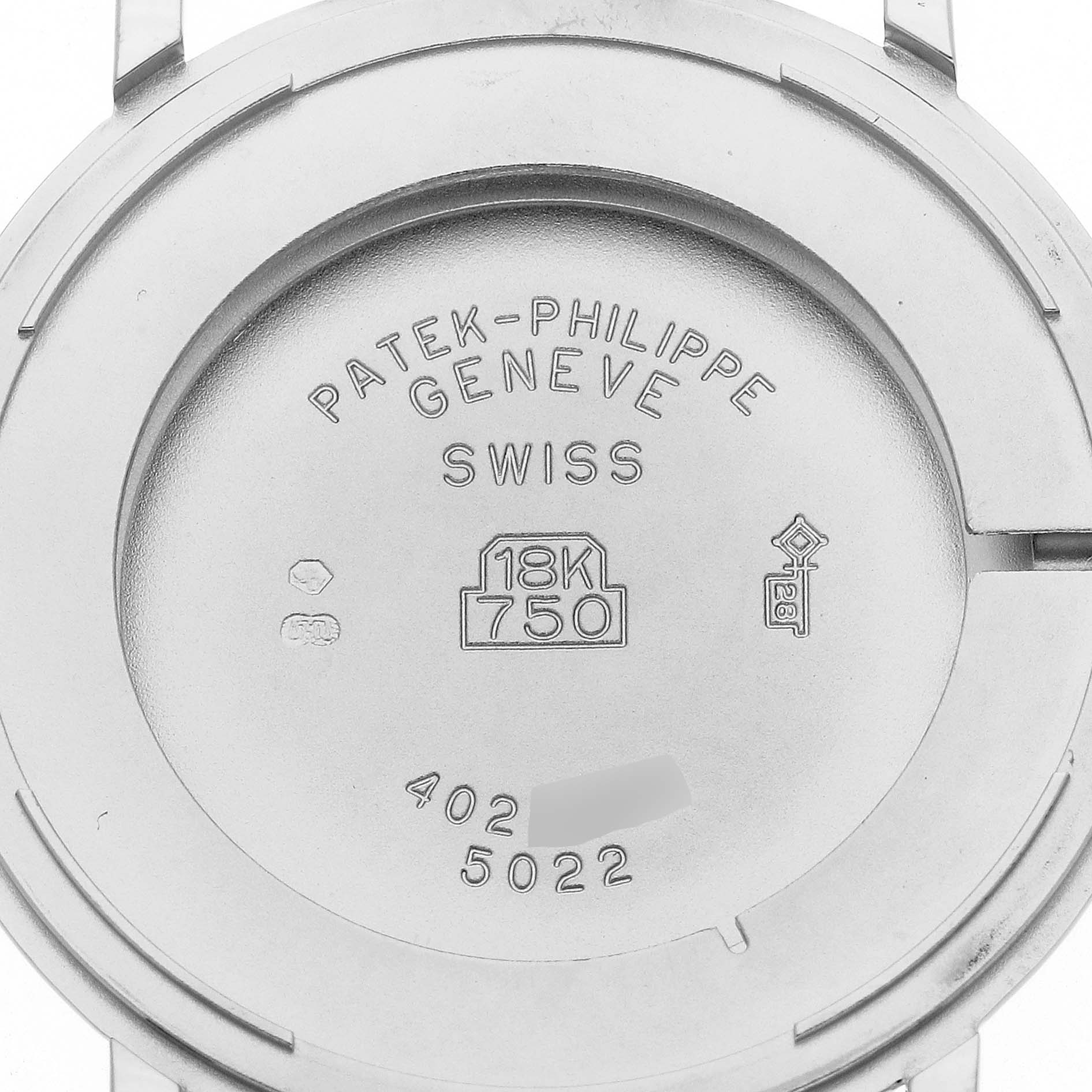 The image shows the back case of a Calatrava model by Patek Philippe, indicating its 18K gold composition and serial numbers.