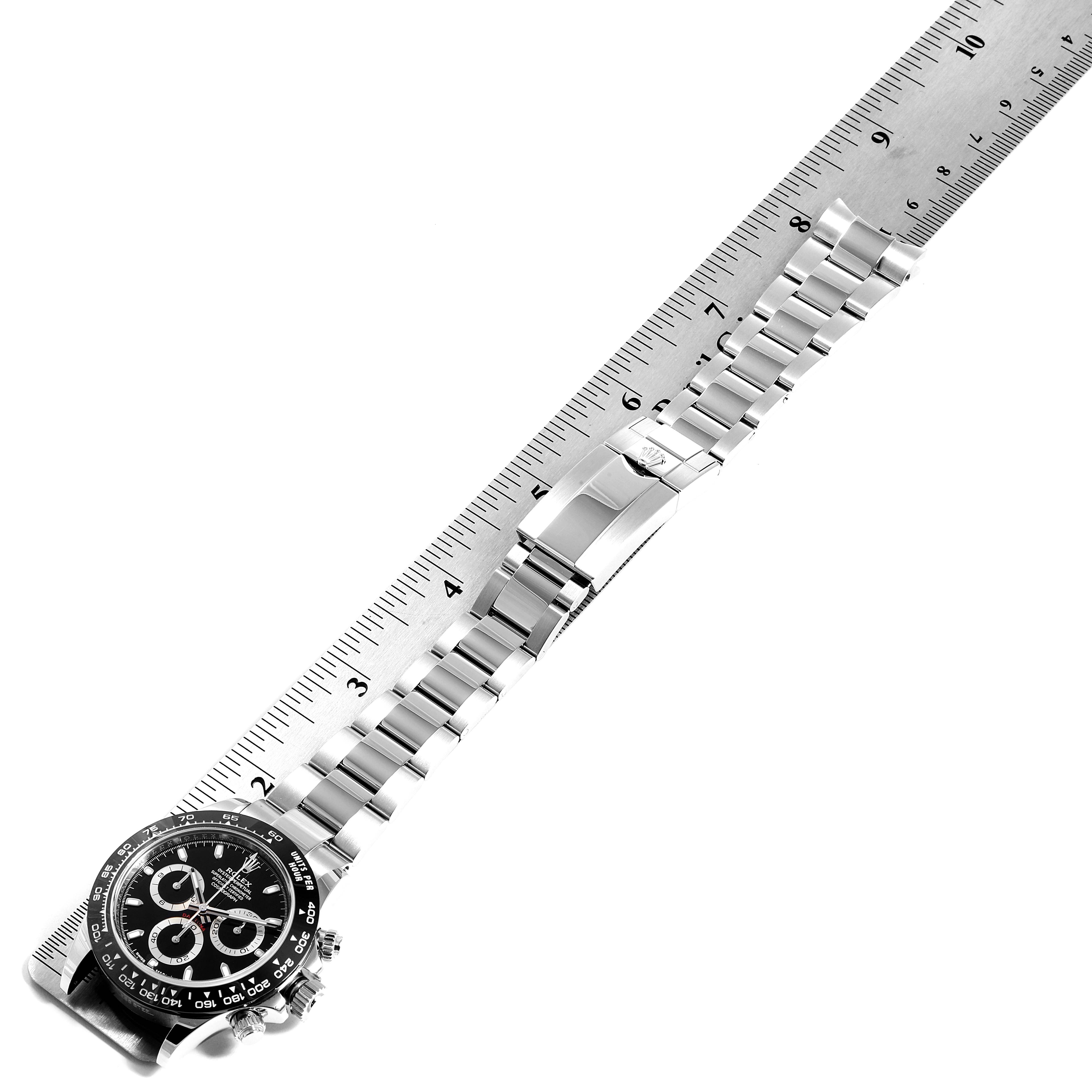 This image shows a side view of a Rolex Daytona 116500 Men's Stainless Steel Black Dial 116500 Men's Stainless Steel Black Dial watch with its bracelet laid alongside a ruler for measurement.