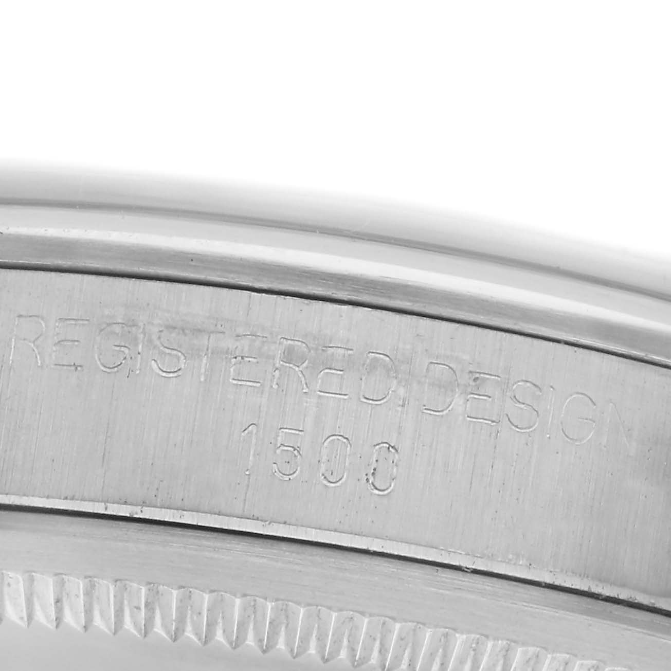 The image shows a macro view of the Rolex Date watch model's inner case, highlighting the "Registered Design" and model number.