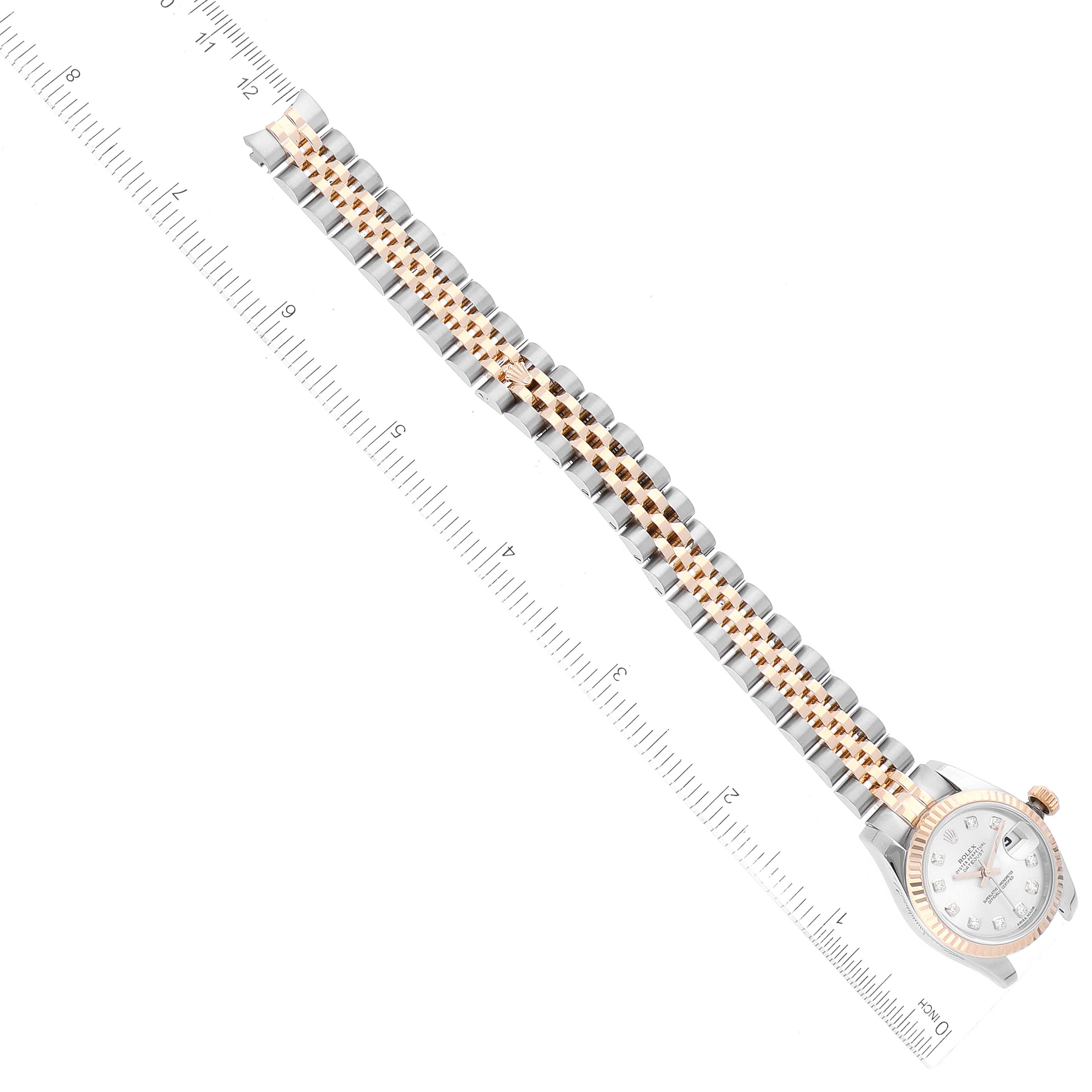 The image shows a Rolex Datejust 179173 Women's Steel and Gold (two tone) Silver Dial 179173 Women's Steel and Gold (two tone) Silver Dial watch with a ruler for scale, displaying the band fully extended and the watch face at the top right.
