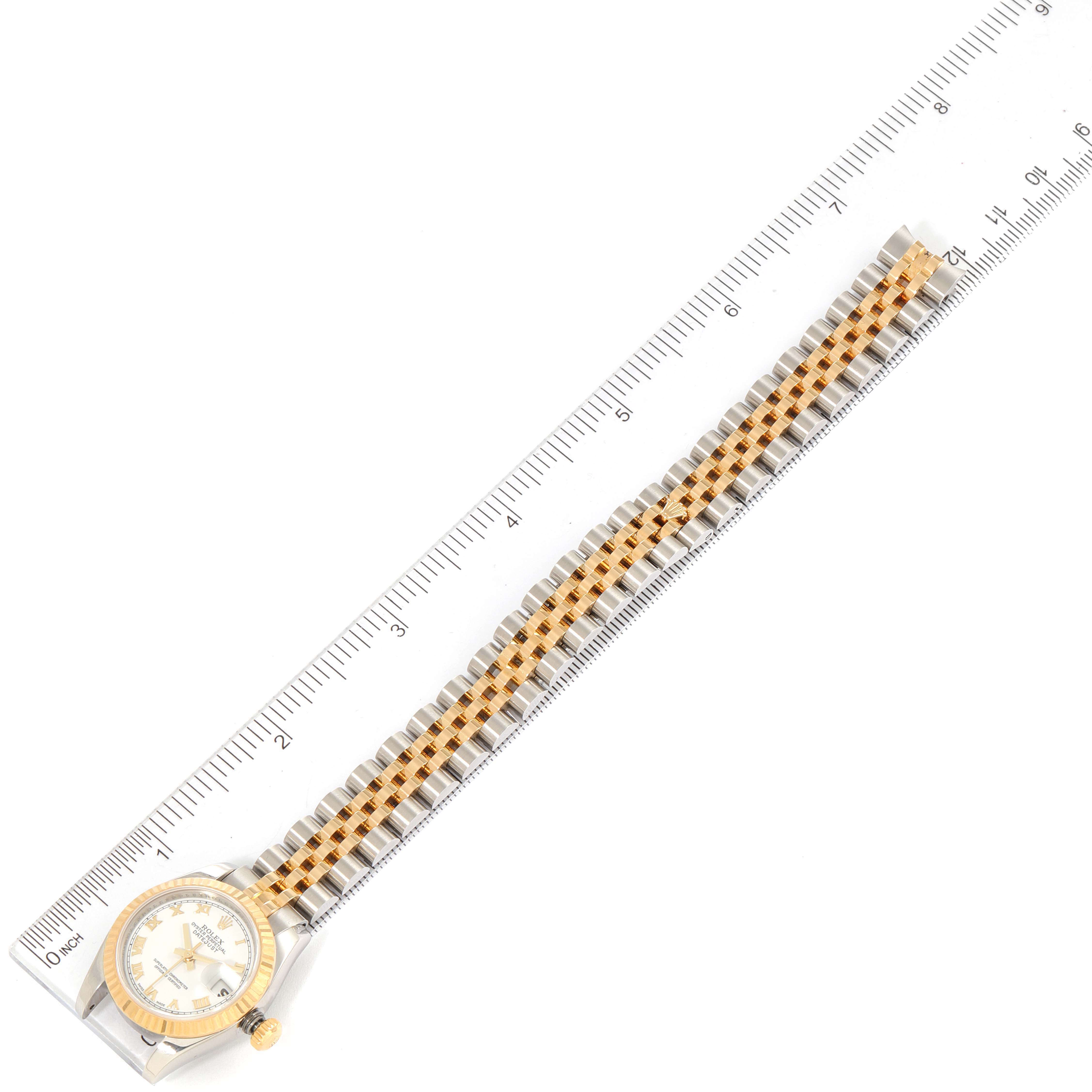 The Rolex Datejust 179173 Women
s Steel and Gold (two tone) White Dial 179173 Women
s Steel and Gold (two tone) White Dial watch is shown from the top, displaying the face and whole bracelet aligned with a ruler.