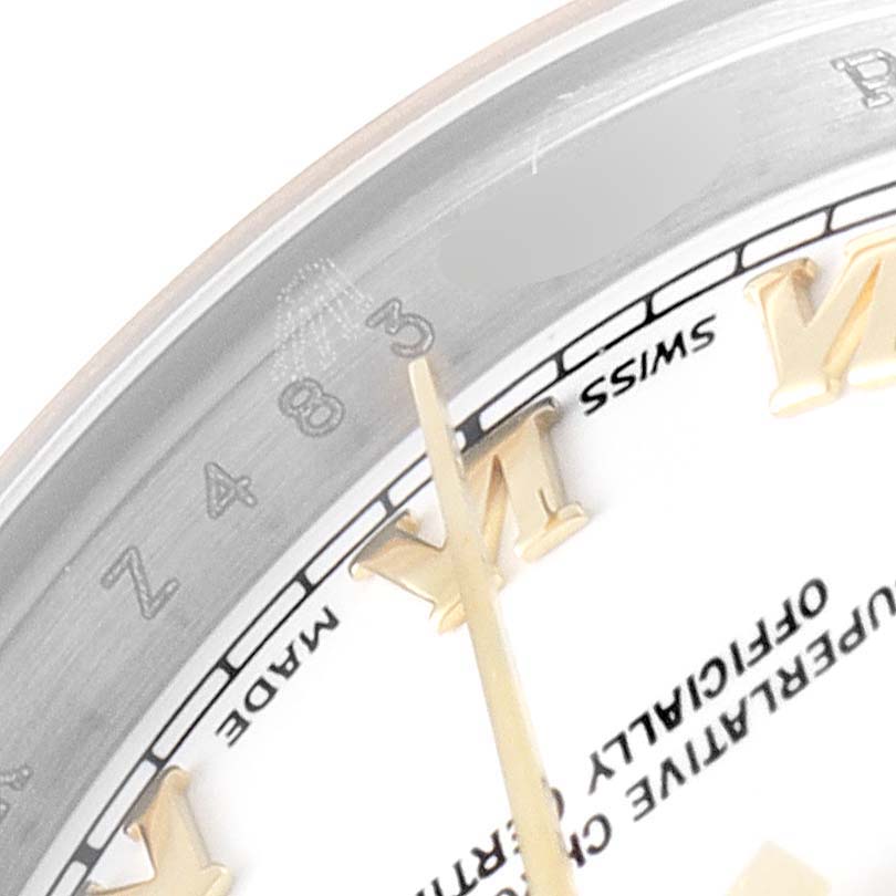 This image shows a close-up of the Datejust Rolex watch
s dial, specifically the Roman numerals and a portion of the serial engraving.