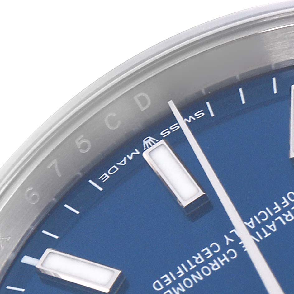 The image shows a close-up of the Rolex Datejust 126200 Men's Stainless Steel Blue Dial 126200 Men's Stainless Steel Blue Dial's blue dial, hour markers, and part of the bezel, viewed from a top angle.