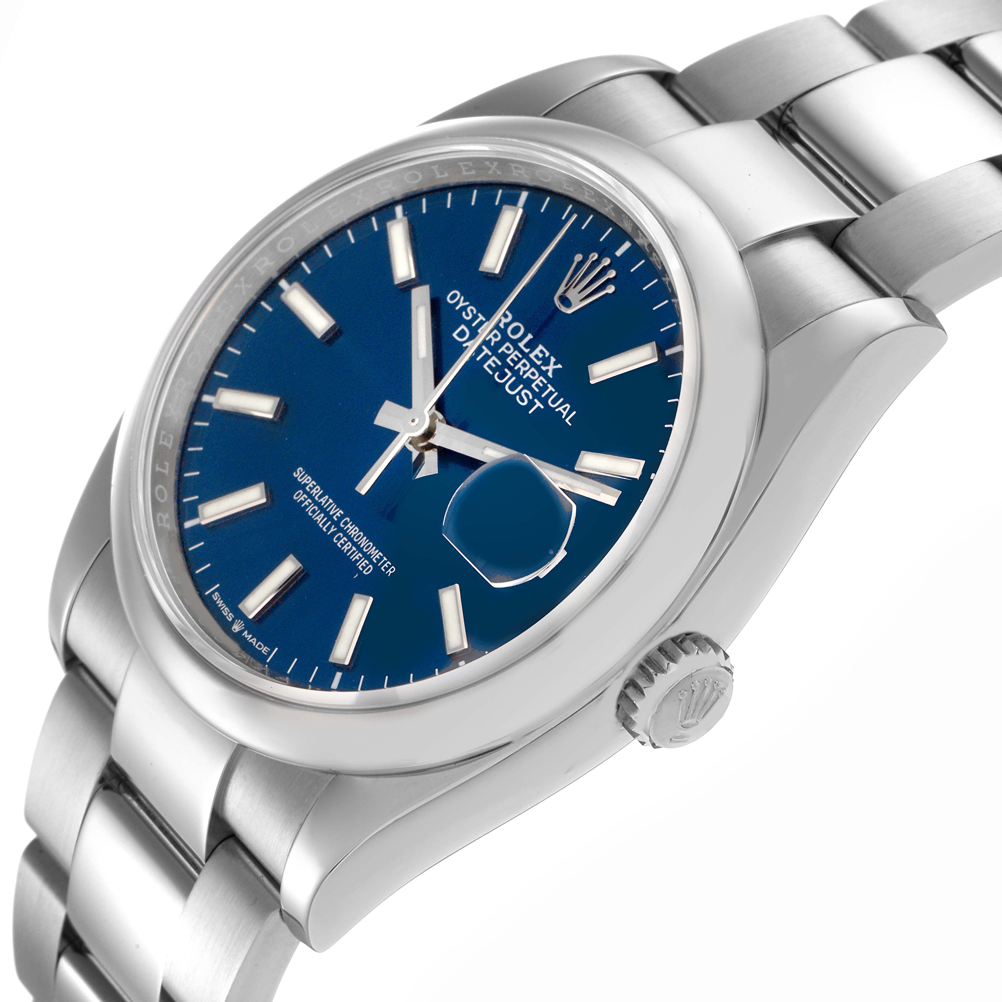 The Rolex Datejust 126200 Men's Stainless Steel Blue Dial 126200 Men's Stainless Steel Blue Dial watch is shown from a slightly angled side view, highlighting the blue dial, bracelet, and crown.
