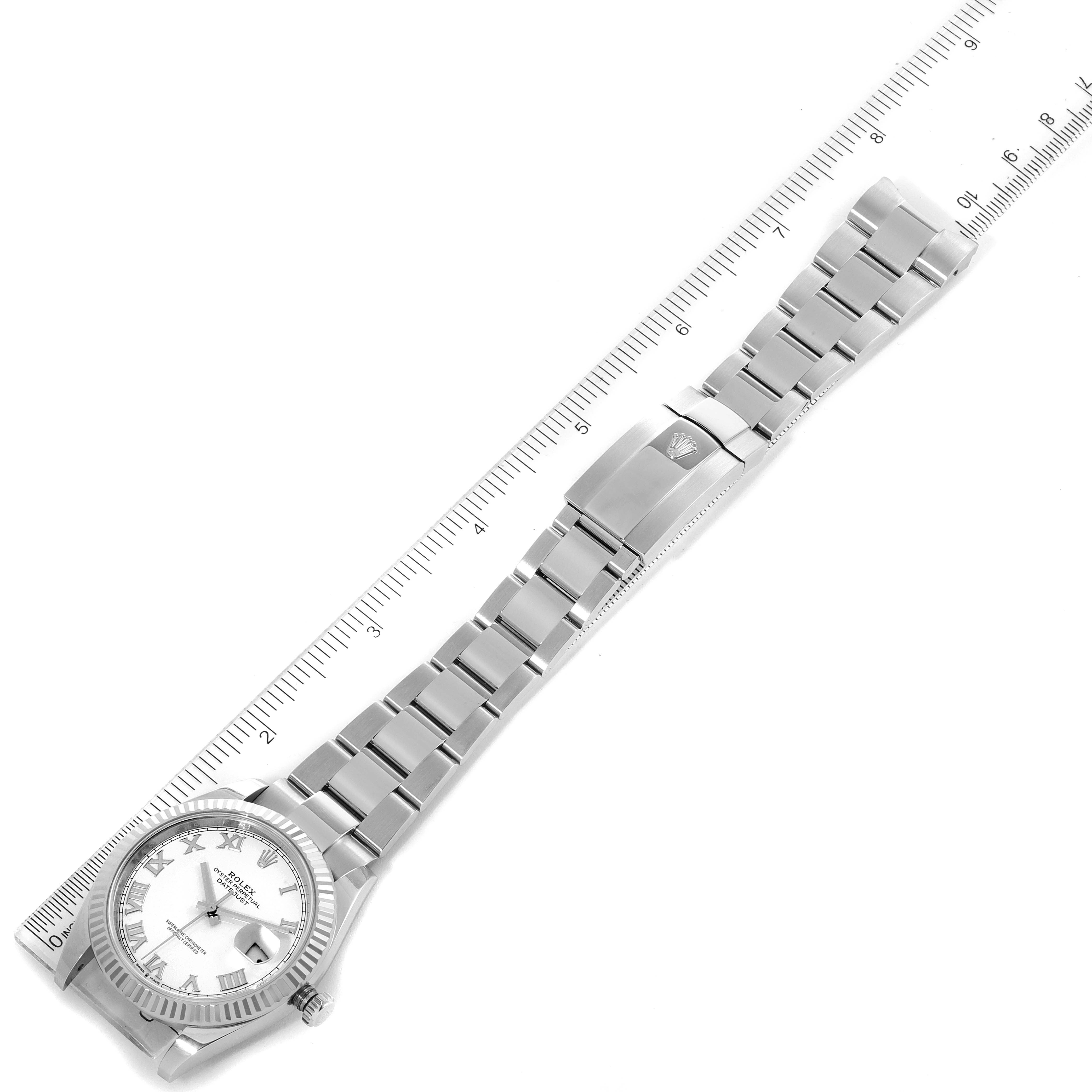 The image displays a top-down view of the Rolex Datejust 41 126334 Men
s Stainless Steel White Dial 126334 Men
s Stainless Steel White Dial watch, showing the face, bracelet, and clasp, alongside a ruler for scale.