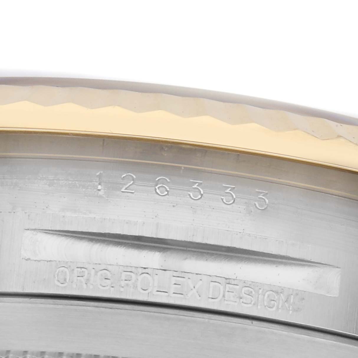 The image shows a close-up of the engraved inner bezel on a Rolex Datejust 41 126333 Men's Steel and Gold (two tone) Silver Dial 126333 Men's Steel and Gold (two tone) Silver Dial, highlighting its serial number and branding.