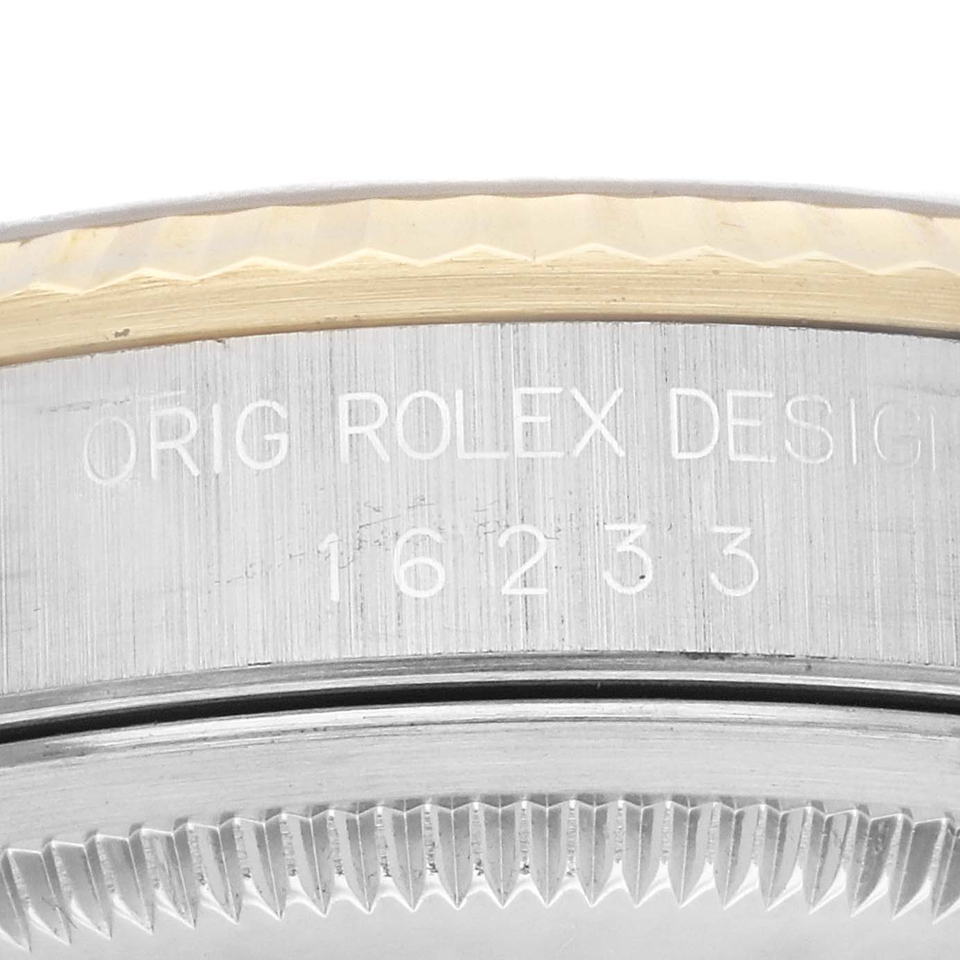 This close-up of a Rolex Datejust 16233 Men's Steel and Gold (two tone) Champagne Dial 16233 Men's Steel and Gold (two tone) Champagne Dial watch shows the engraved model number and part of the bezel and case.