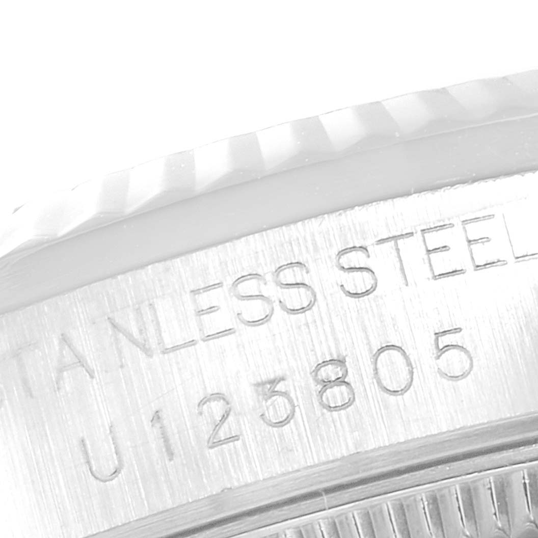 This image shows a close-up of the case back and part of the bezel of a Rolex Mid-Size 68274 Women
s Stainless Steel White Dial 68274 Women
s Stainless Steel White Dial model, highlighting the serial number and "Stainless Steel" engraving.