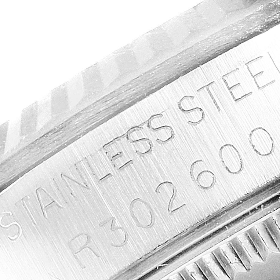 This is a close-up of the casing and part of the bezel on a Mid-Size Rolex watch, showing the engraved text "STAINLESS STEEL."
