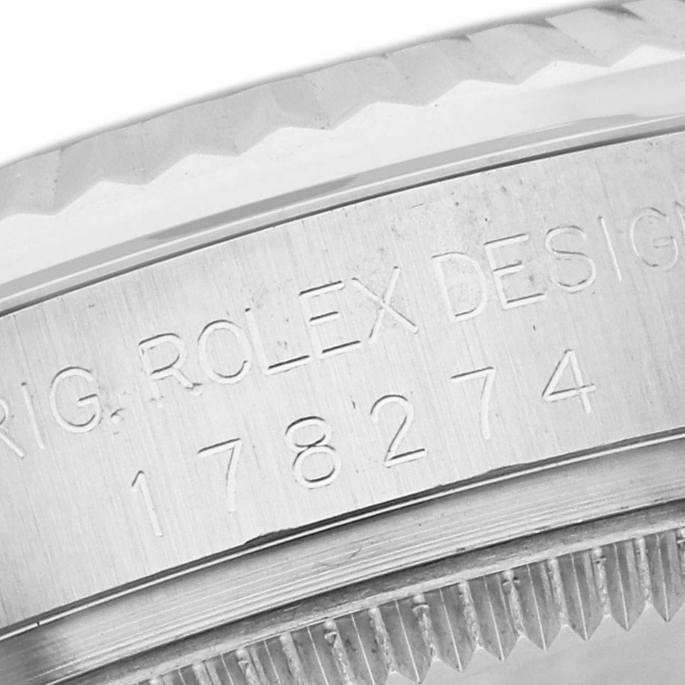 This close-up image of a Rolex Mid-Size 178274 Women's Stainless Steel Silver Dial 178274 Women's Stainless Steel Silver Dial model focuses on the engraved serial number and part of the bezel.