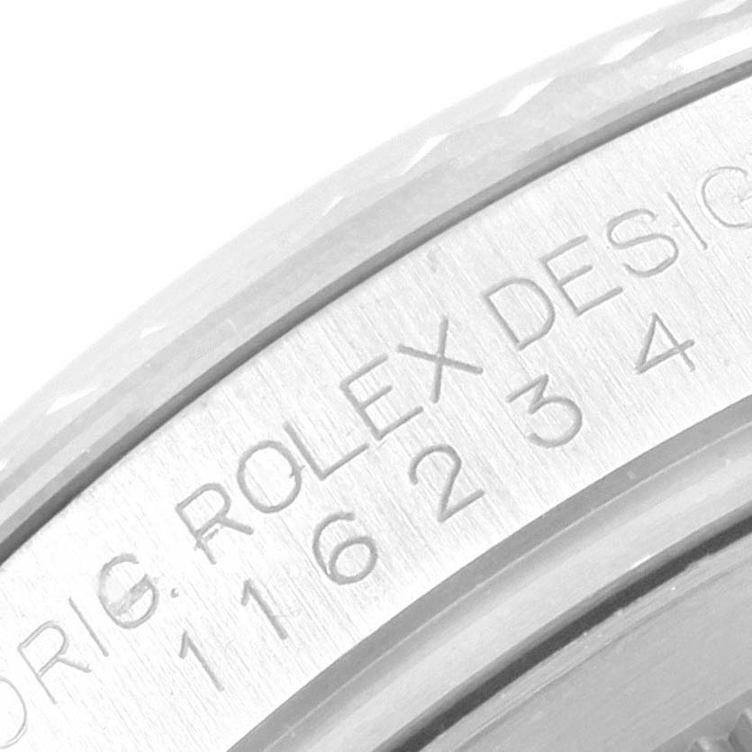This close-up image of a Rolex Datejust 116234 Men's Stainless Steel Black Dial 116234 Men's Stainless Steel Black Dial watch shows the engraved serial number and branding on the watch case.