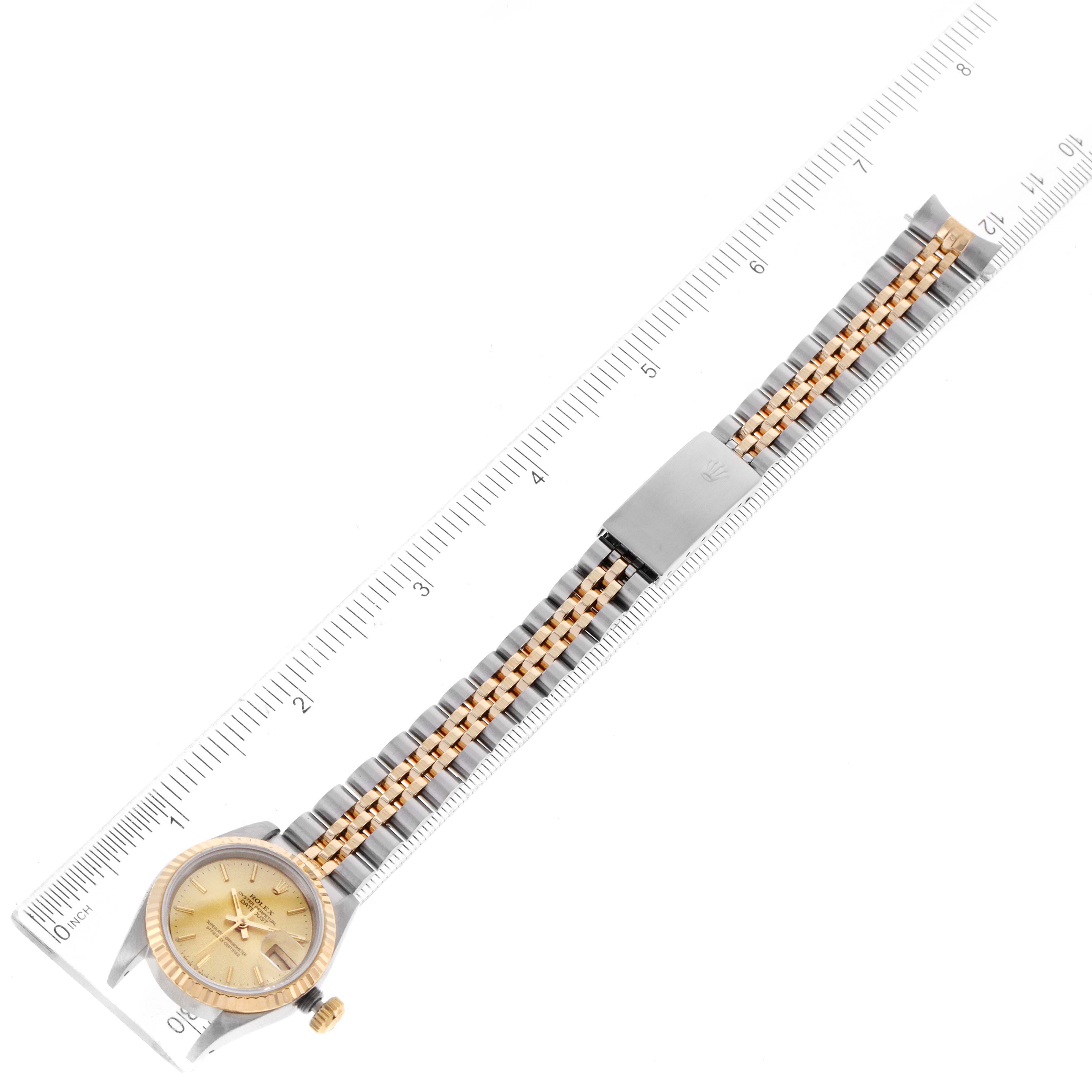 The Rolex Datejust 69173 Women
s Steel and Gold (two tone) Champagne Dial 69173 Women
s Steel and Gold (two tone) Champagne Dial watch is shown from an overhead angle, displaying the face, case, and full two-tone bracelet along a ruler.