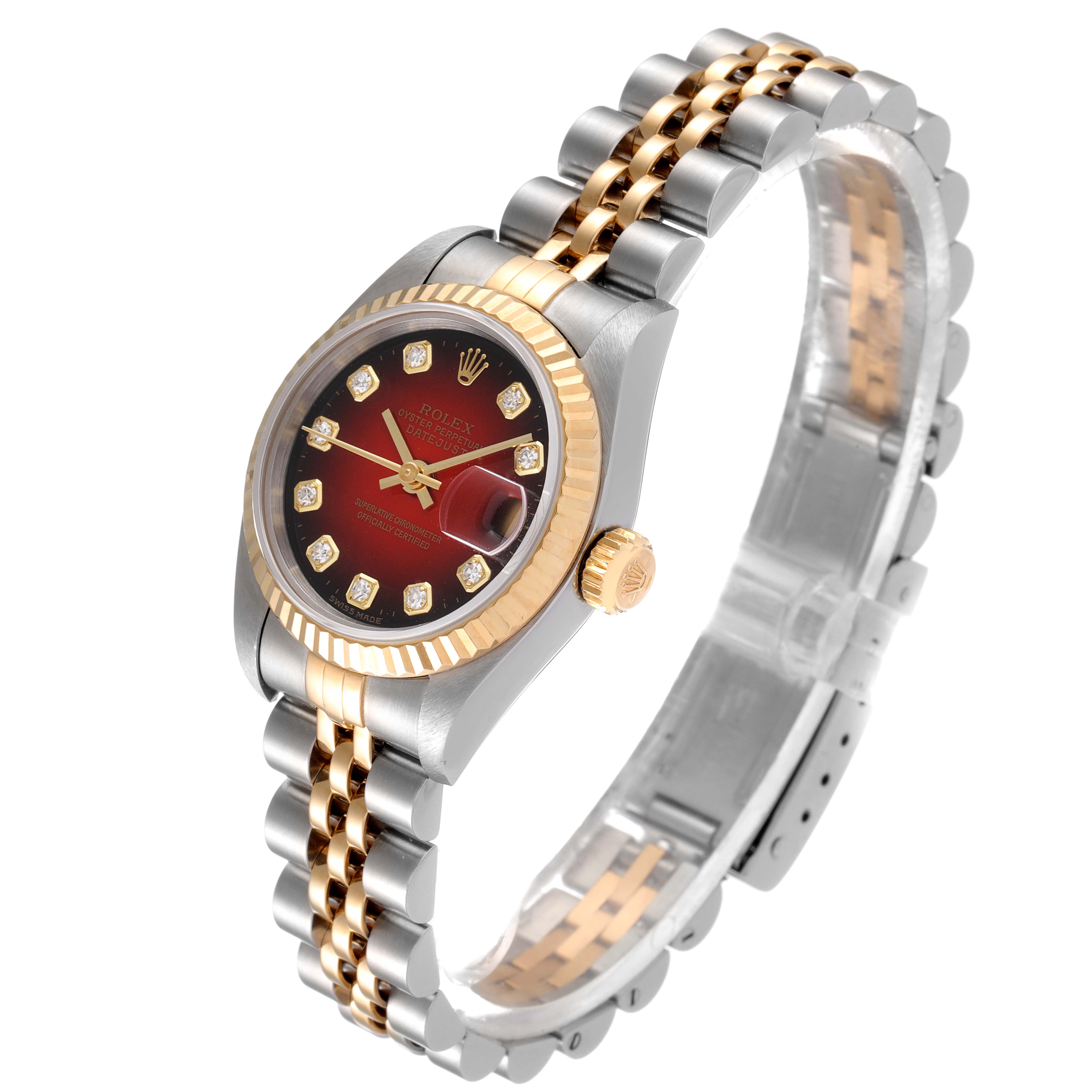The image shows a Rolex Datejust 79173 Women
s Steel and Gold (two tone) Red Dial 79173 Women
s Steel and Gold (two tone) Red Dial watch at an angled view, highlighting its face, bezel, crown, and two-tone bracelet.