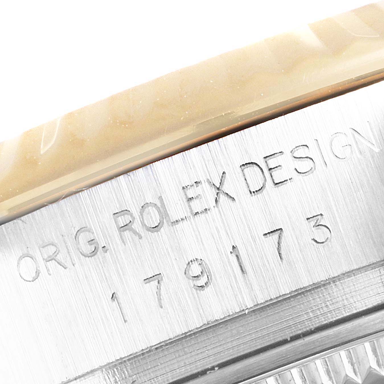 This image shows a close-up of a Rolex Datejust 179173 Women
s Steel and Gold (two tone) Black Dial 179173 Women
s Steel and Gold (two tone) Black Dial model’s engraved case details, highlighting the text "ORIG. ROLEX DESIGN."