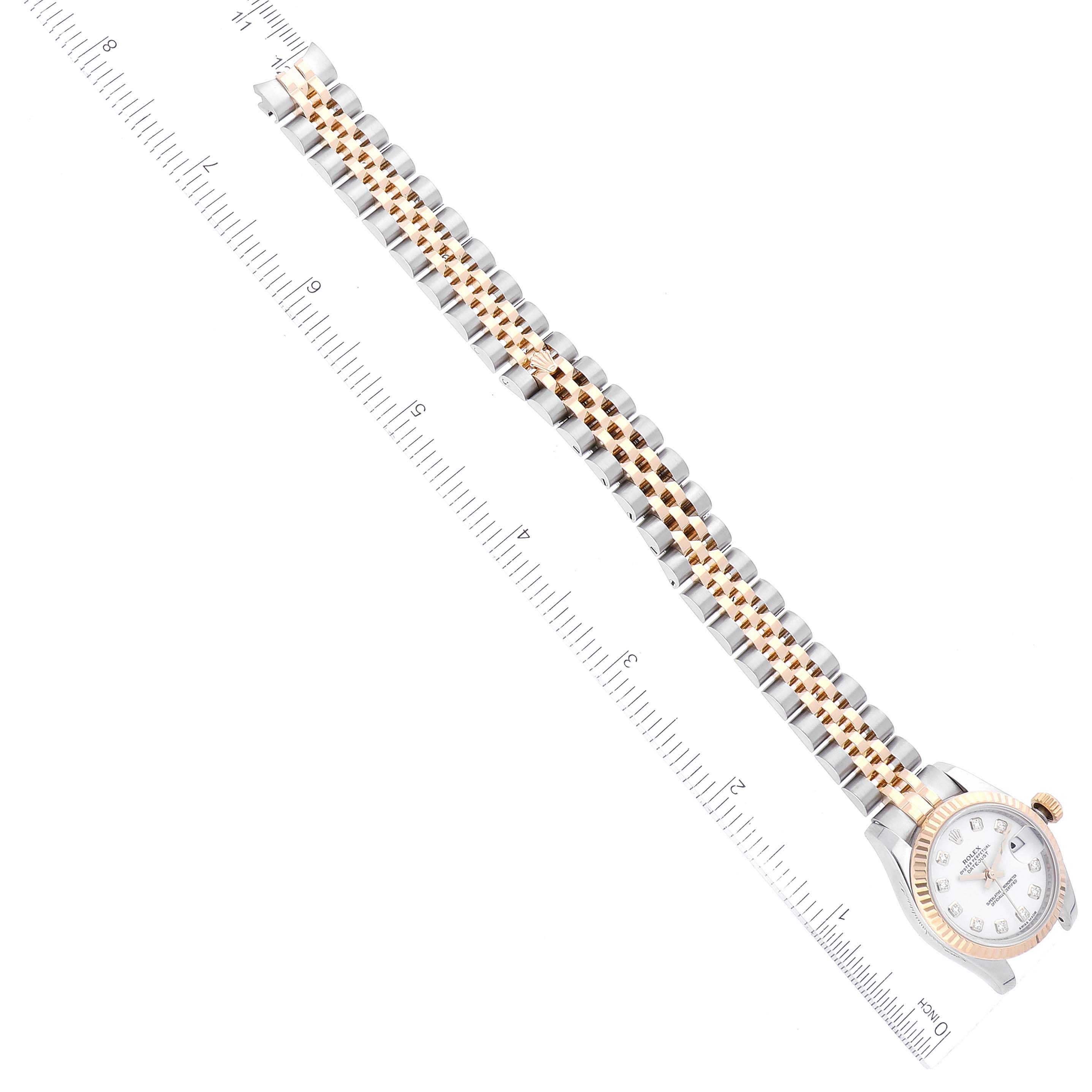 This image shows a Rolex Datejust 179173 Women's Steel and Gold (two tone) White Dial 179173 Women's Steel and Gold (two tone) White Dial watch lying flat with a full view of its bracelet and a measuring ruler beside it.