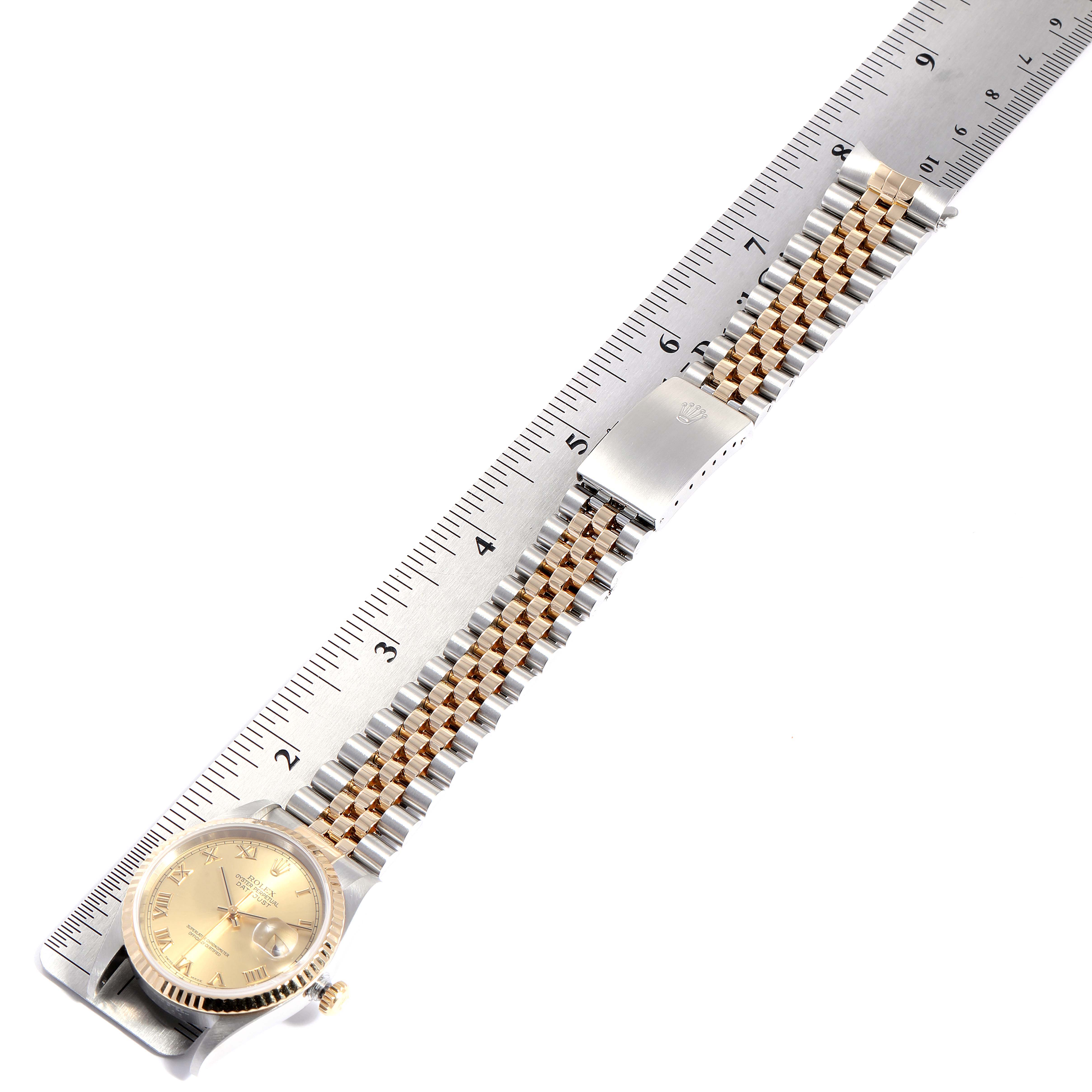 This image shows the Rolex Datejust 16233 Men's Steel and Gold (two tone) Champagne Dial 16233 Men's Steel and Gold (two tone) Champagne Dial watch placed aligned with a ruler, highlighting the face, band, and clasp from a top-down angle.