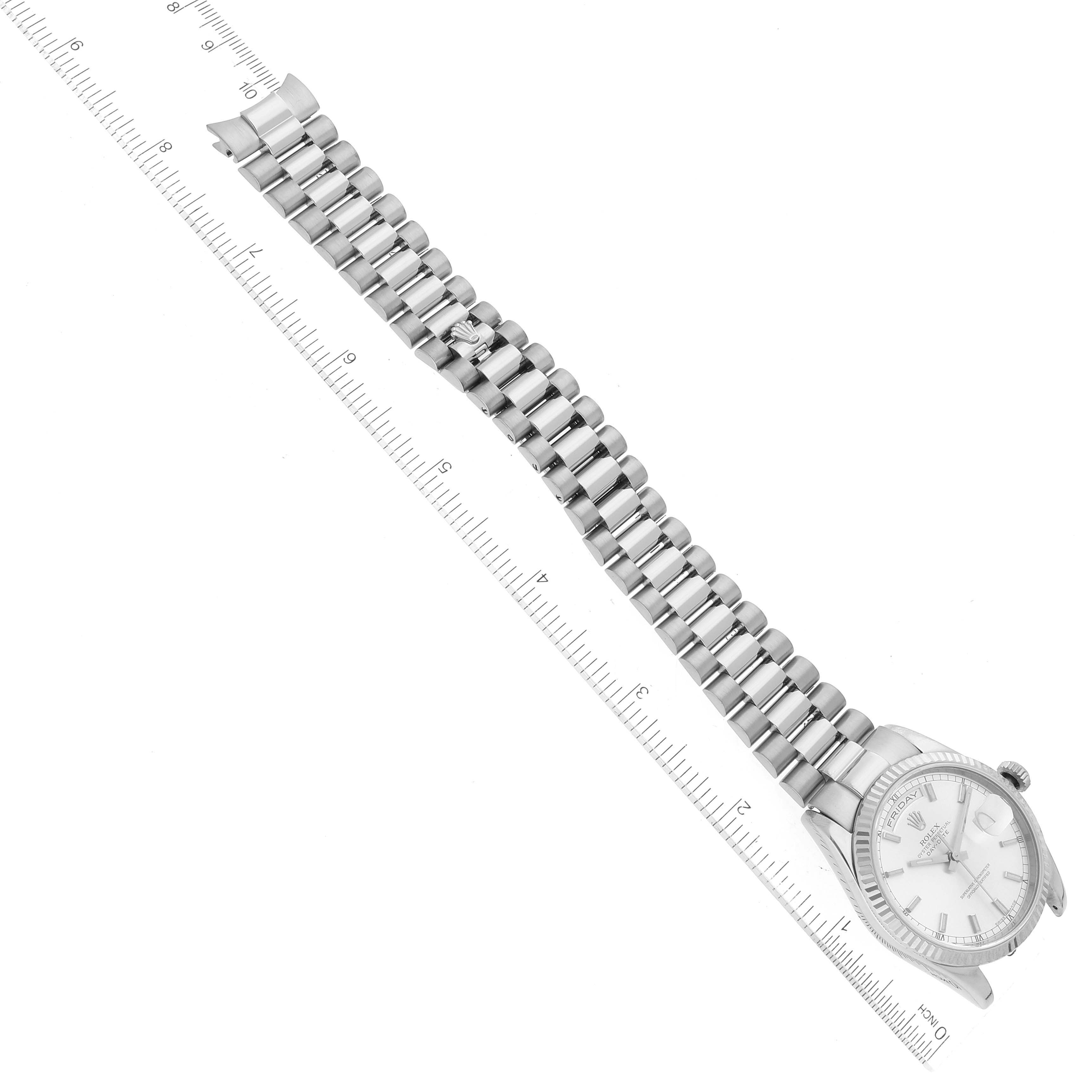 The Rolex President 118239 Men's White Gold Silver Dial 118239 Men's White Gold Silver Dial model watch is shown at an angled view, highlighting the watch’s bracelet and face with a ruler beside it.