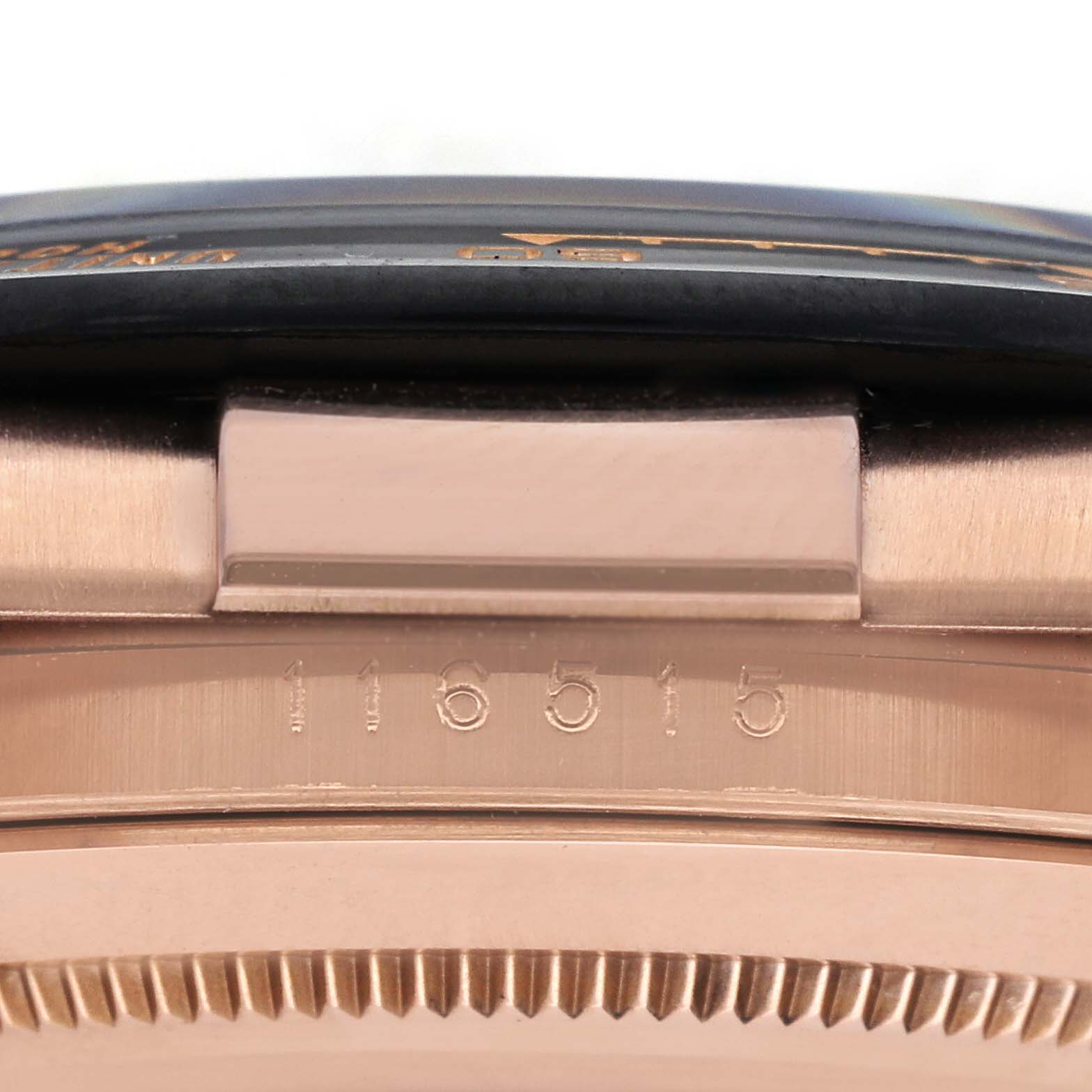 The image shows a side view of the Rolex Daytona 116515LN Men's Rose Gold Black Dial 116515LN Men's Rose Gold Black Dial model, focusing on the case edge and part of the bezel with engravings.