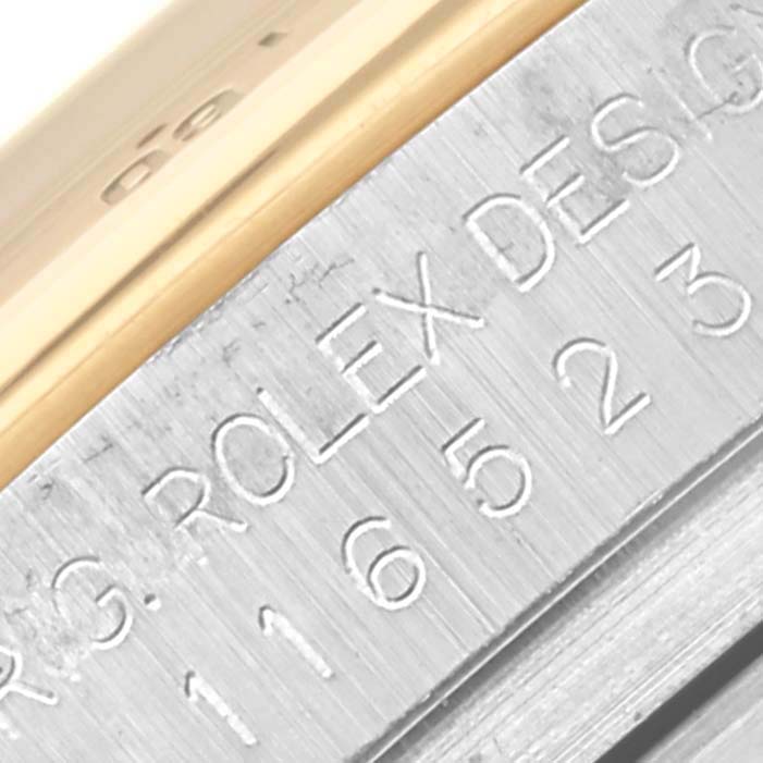 The image shows a close-up of the side of a Rolex Daytona 116523NR Men
s Steel and Gold (two tone) Mother of Pearl Dial 116523NR Men
s Steel and Gold (two tone) Mother of Pearl Dial watch, highlighting the engraving on the metal surface.