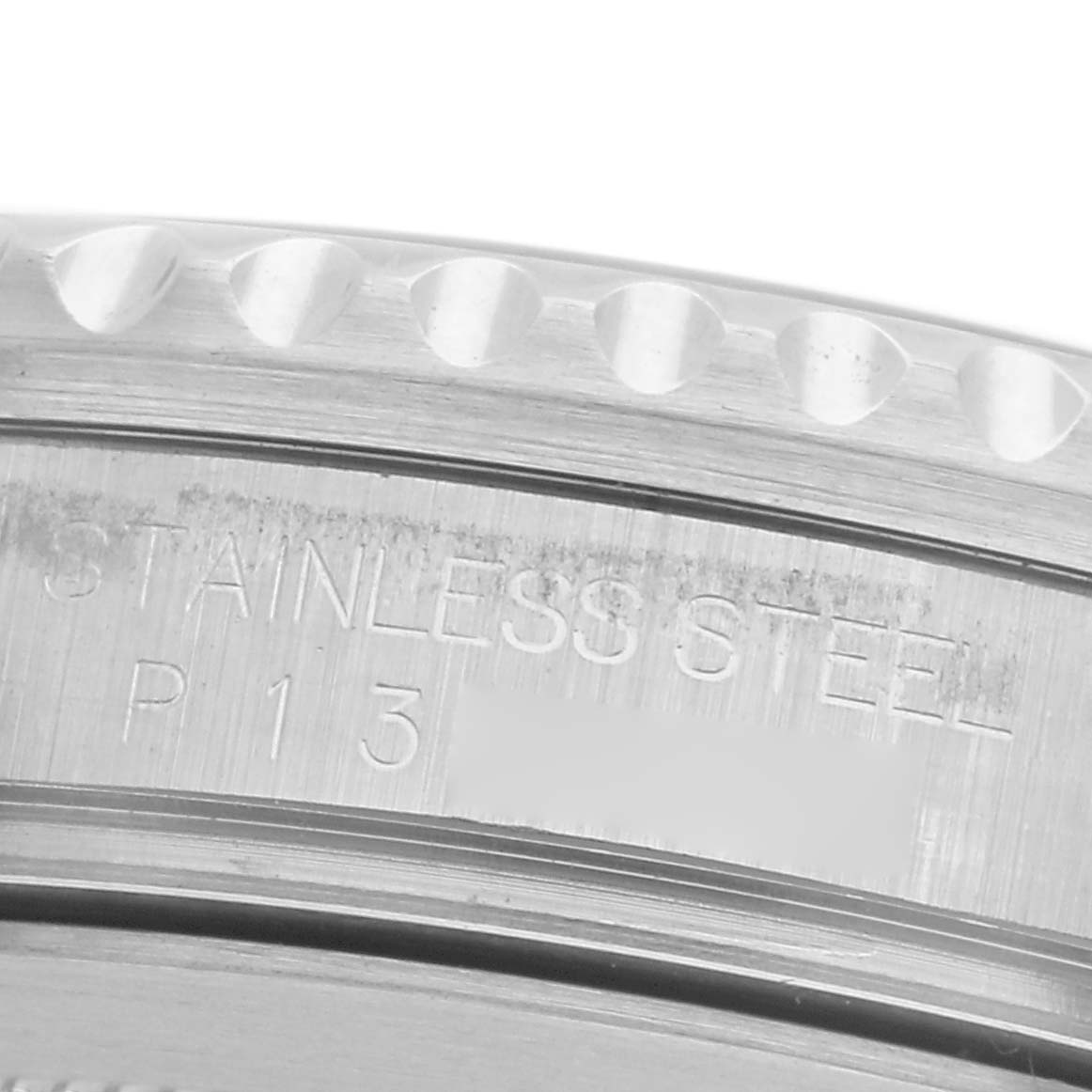 The image shows a close-up of the side of a Rolex GMT-Master 16710 Men's Stainless Steel Black Dial 16710 Men's Stainless Steel Black Dial watch, focusing on the stainless steel case with engraved text.