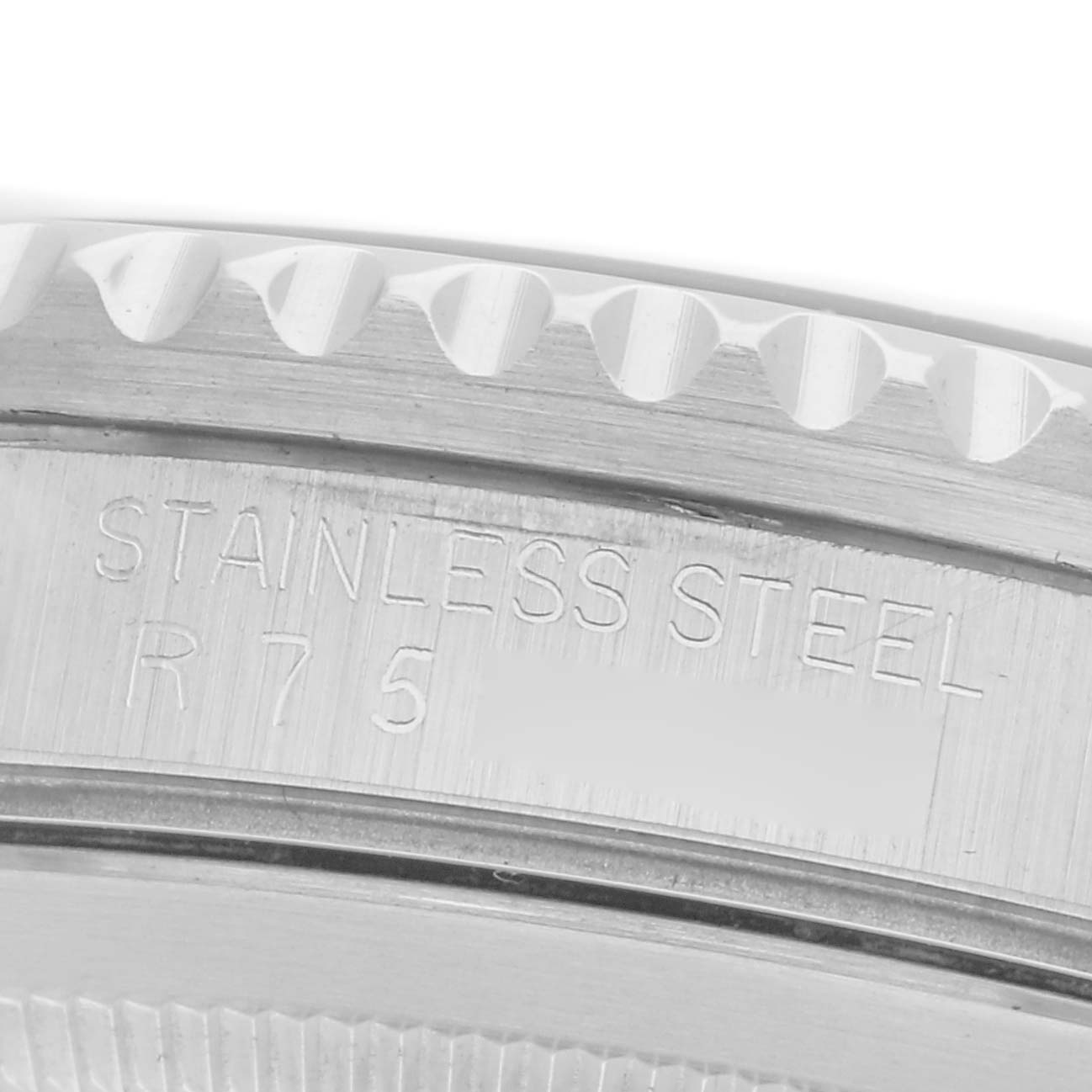 The image shows a close-up of the Rolex GMT-Master 16700 Men's Stainless Steel Black Dial 16700 Men's Stainless Steel Black Dial's stainless steel case back, highlighting part of the bezel and engraved lettering.