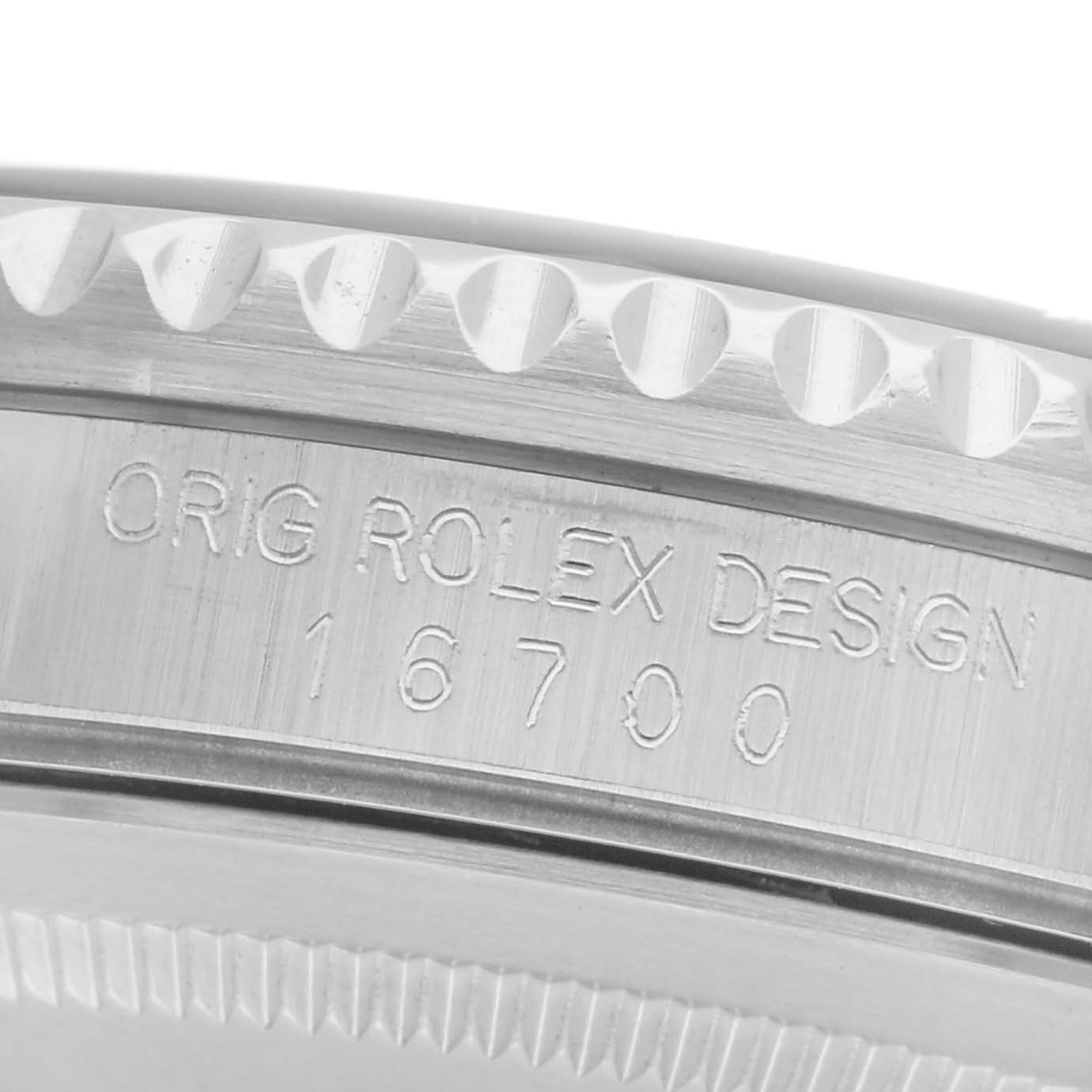 The image shows a close-up of the side engraving on a Rolex GMT-Master 16700 Men's Stainless Steel Black Dial 16700 Men's Stainless Steel Black Dial's case, highlighting the "Orig Rolex Design 16700" text.