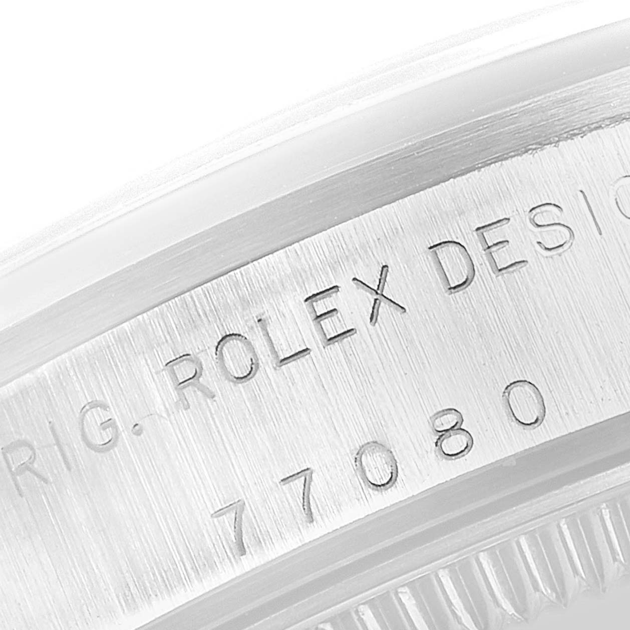 This image shows a close-up view of the side engraving on a Rolex Mid-Size 77080 Women
s Stainless Steel Pink Dial 77080 Women
s Stainless Steel Pink Dial watch case, displaying parts of the serial and model numbers.