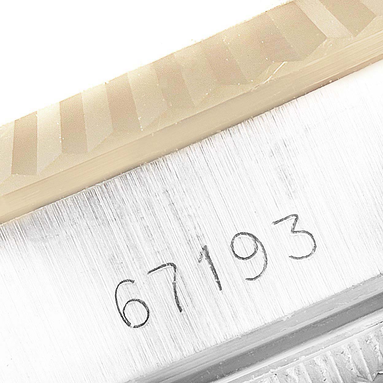 This image shows the engraved model number 67193 on the side of a Rolex Oyster Perpetual 67193 Women
s Steel and Gold (two tone) Champagne Dial 67193 Women
s Steel and Gold (two tone) Champagne Dial watch
s case.