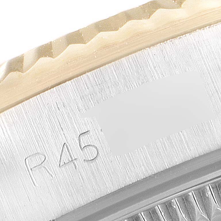 This close-up of a Rolex Oyster Perpetual 67193 Women
s Steel and Gold (two tone) Champagne Dial 67193 Women
s Steel and Gold (two tone) Champagne Dial watch shows part of the bezel and engraved model number.