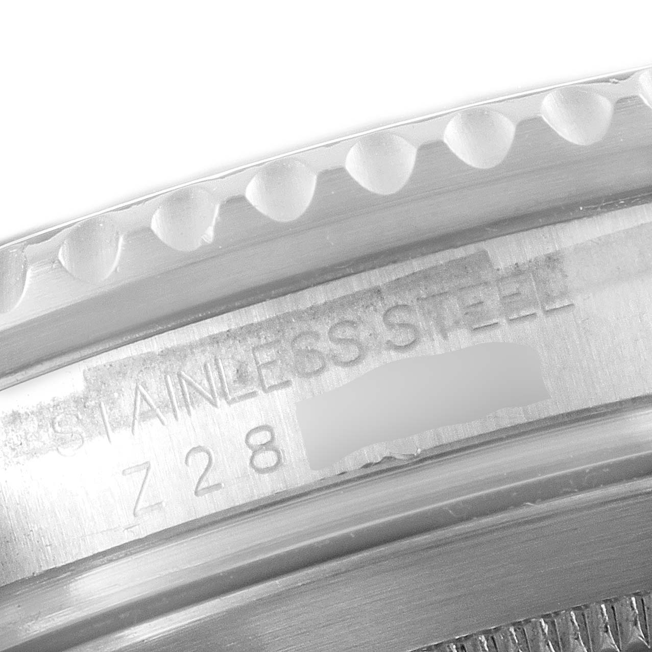 The image shows a close-up of the stainless steel case back and edge of the bezel of a Rolex Submariner 16610 Men
s Stainless Steel Black Dial 16610 Men
s Stainless Steel Black Dial.