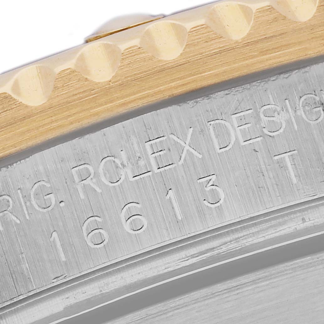 This image shows the edge of the bezel and the engraved side of the case, including the model number, of a Rolex Submariner 16613 Men's Steel and Gold (two tone) Blue Dial 16613 Men's Steel and Gold (two tone) Blue Dial watch.