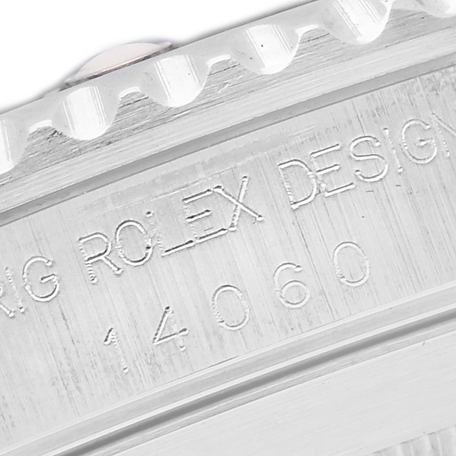 The image shows the edge and engraved details of a Rolex Submariner 14060 Men's Stainless Steel Black Dial 14060 Men's Stainless Steel Black Dial watch case at a close angle.