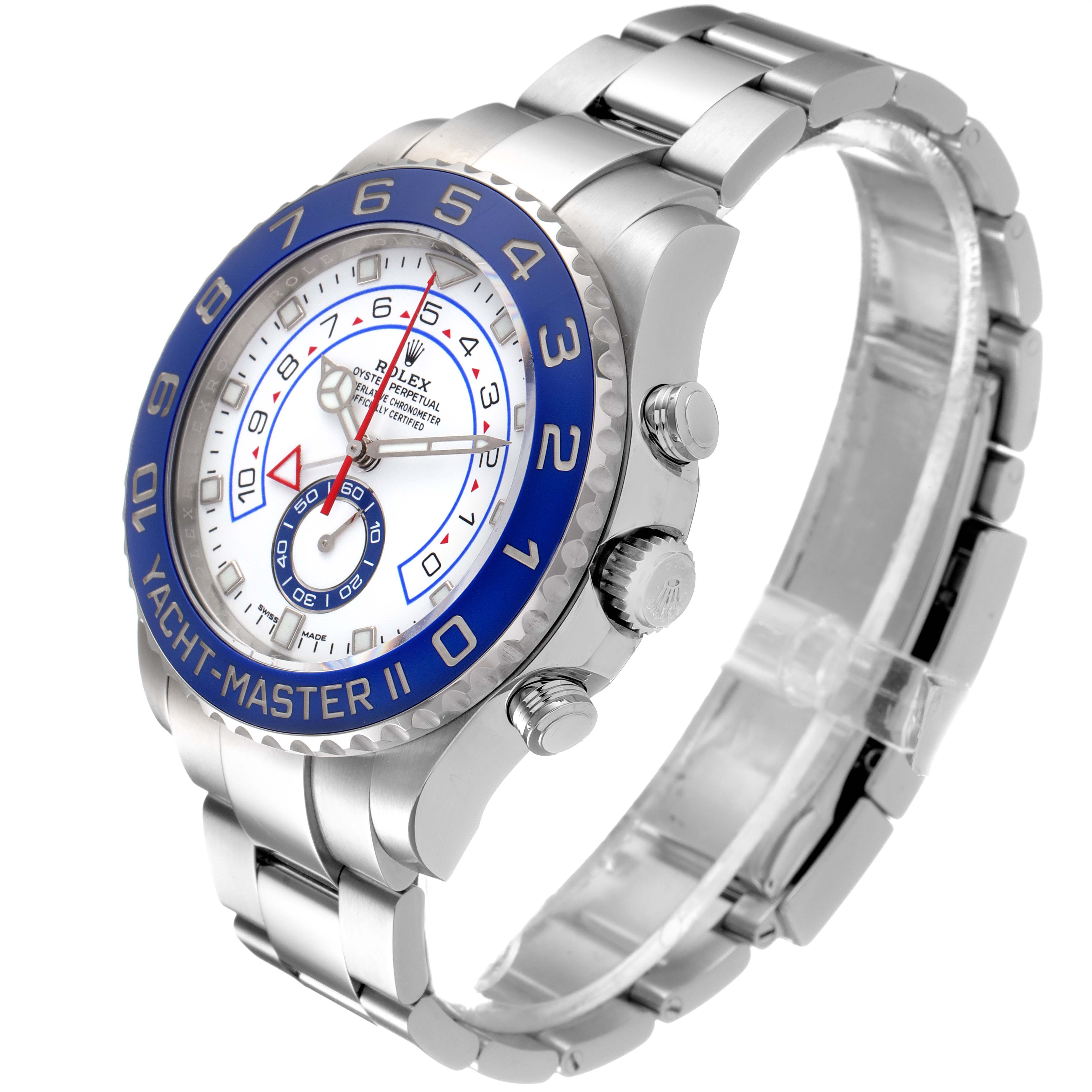 The image shows a Rolex Yacht-Master 116680 Men
s Stainless Steel White Dial 116680 Men
s Stainless Steel White Dial II watch from a front-left angle, highlighting its blue bezel, dial, and bracelet.