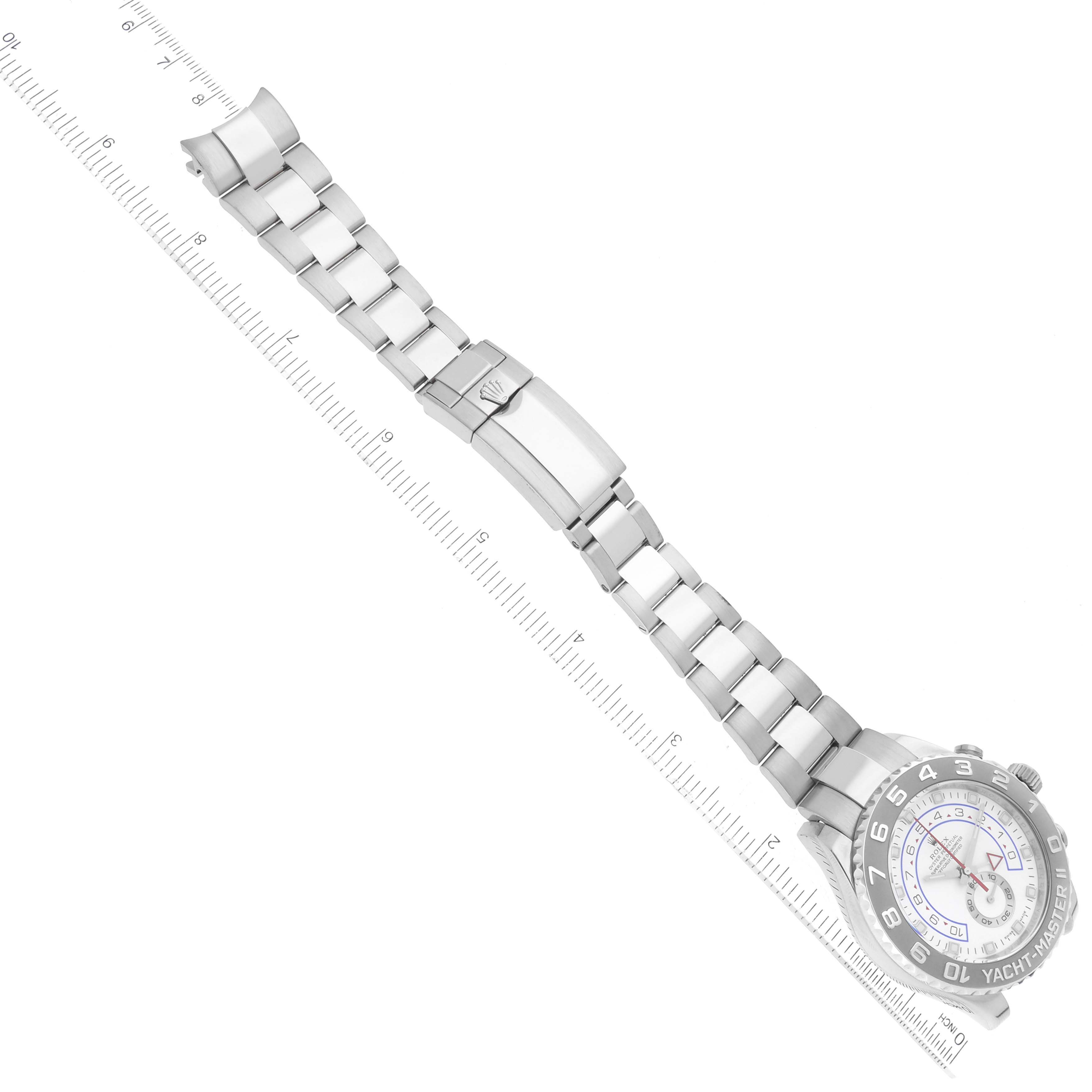 The image shows a Rolex Yacht-Master 116689 Men's White Gold White Dial 116689 Men's White Gold White Dial watch laid flat with its bracelet extended next to a ruler.