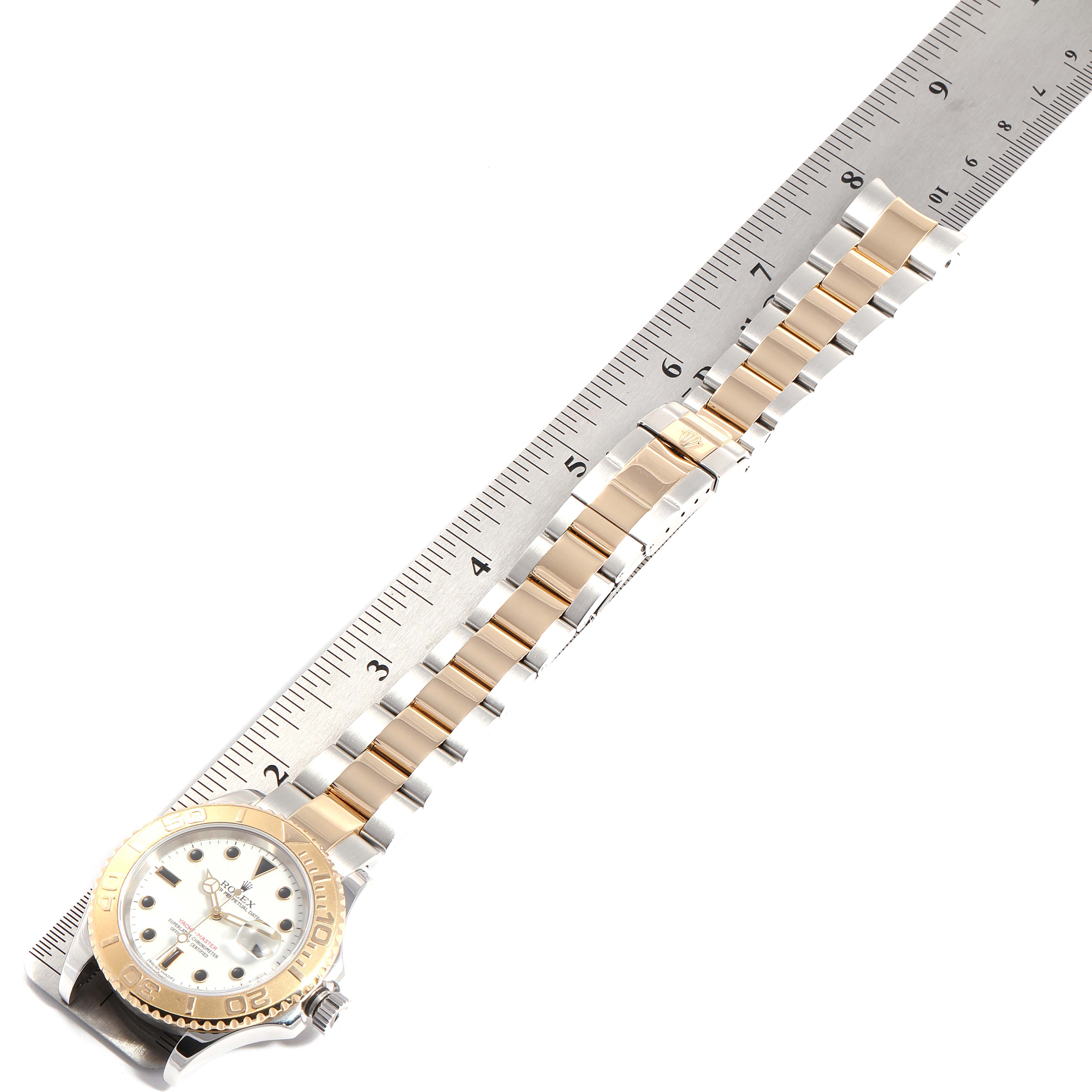The image shows a Rolex Yacht-Master 16623  Men
s Steel and Gold (two tone) White Dial 16623  Men
s Steel and Gold (two tone) White Dial watch laid flat with a ruler beside it, displaying the full bracelet for measurement.