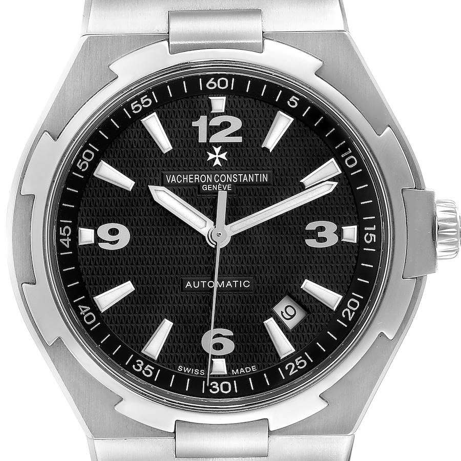 The Vacheron Constantin Overseas watch is shown from a front angle, highlighting its black dial, markers, and date window.