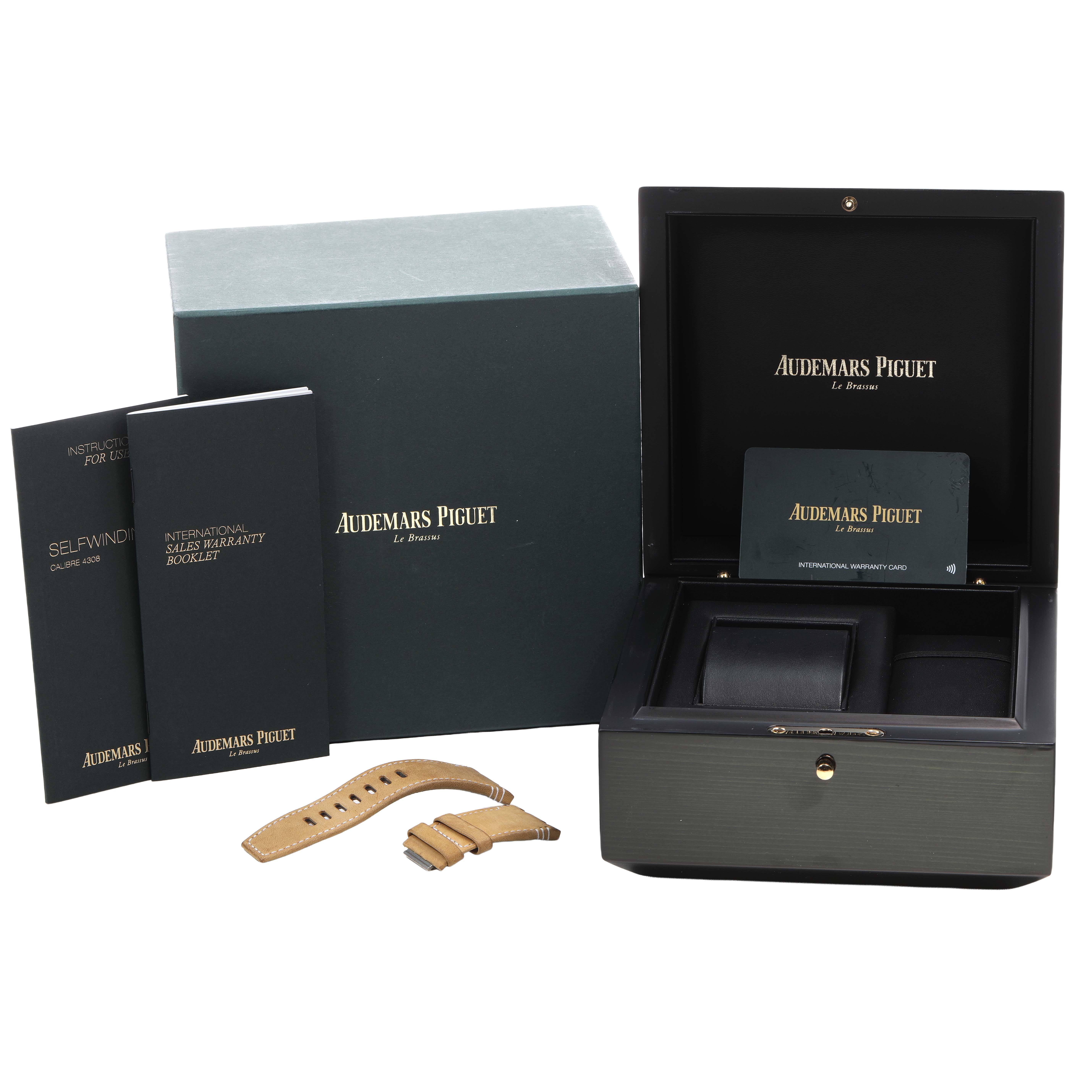 The image shows a Royal Oak Offshore watch box and accessories by Audemars Piguet, including straps, booklets, and a warranty card.