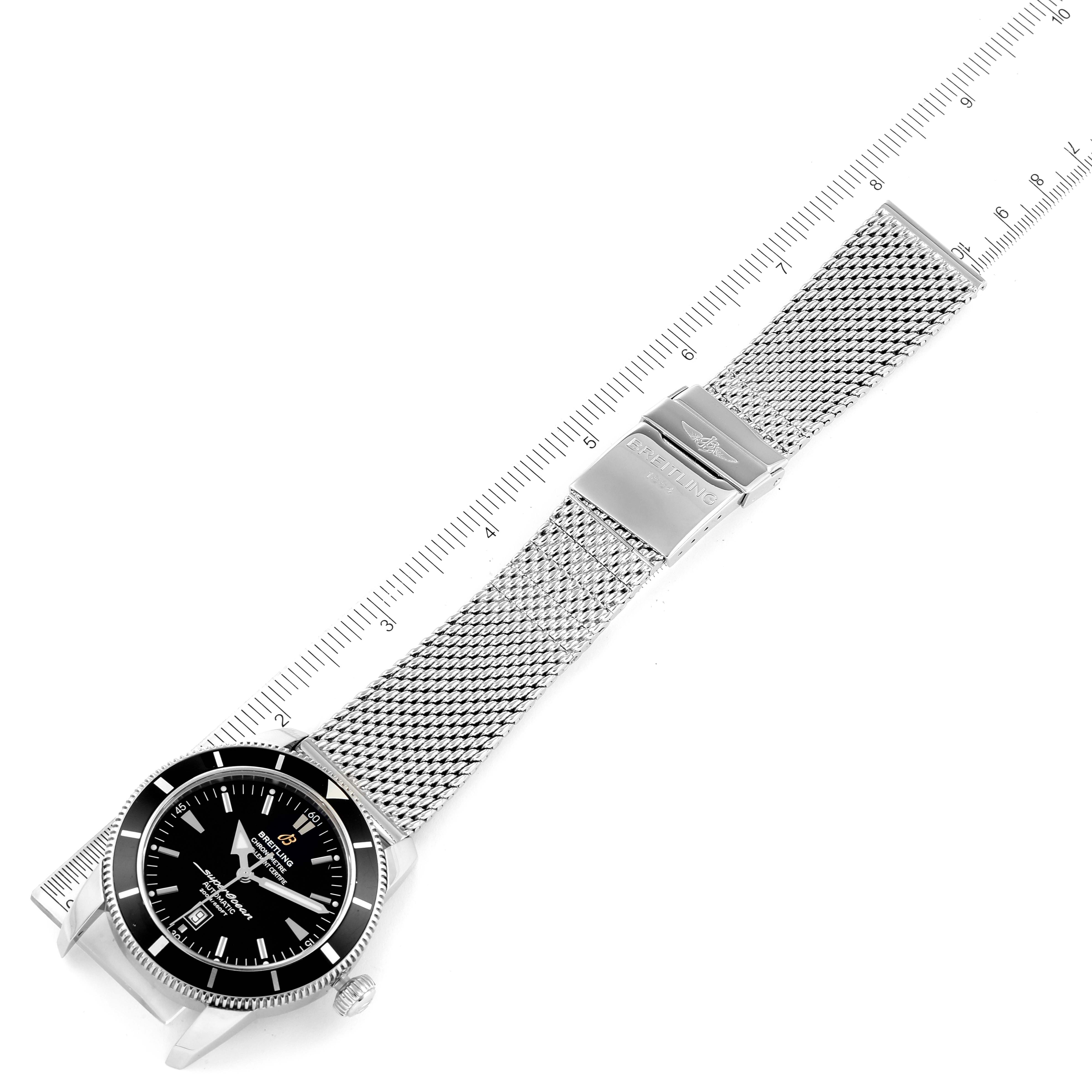 The image shows a top-down view of a Breitling Superocean A17320 Men's Stainless Steel Black Dial A17320 Men's Stainless Steel Black Dial watch with a mesh bracelet and a ruler for scale.