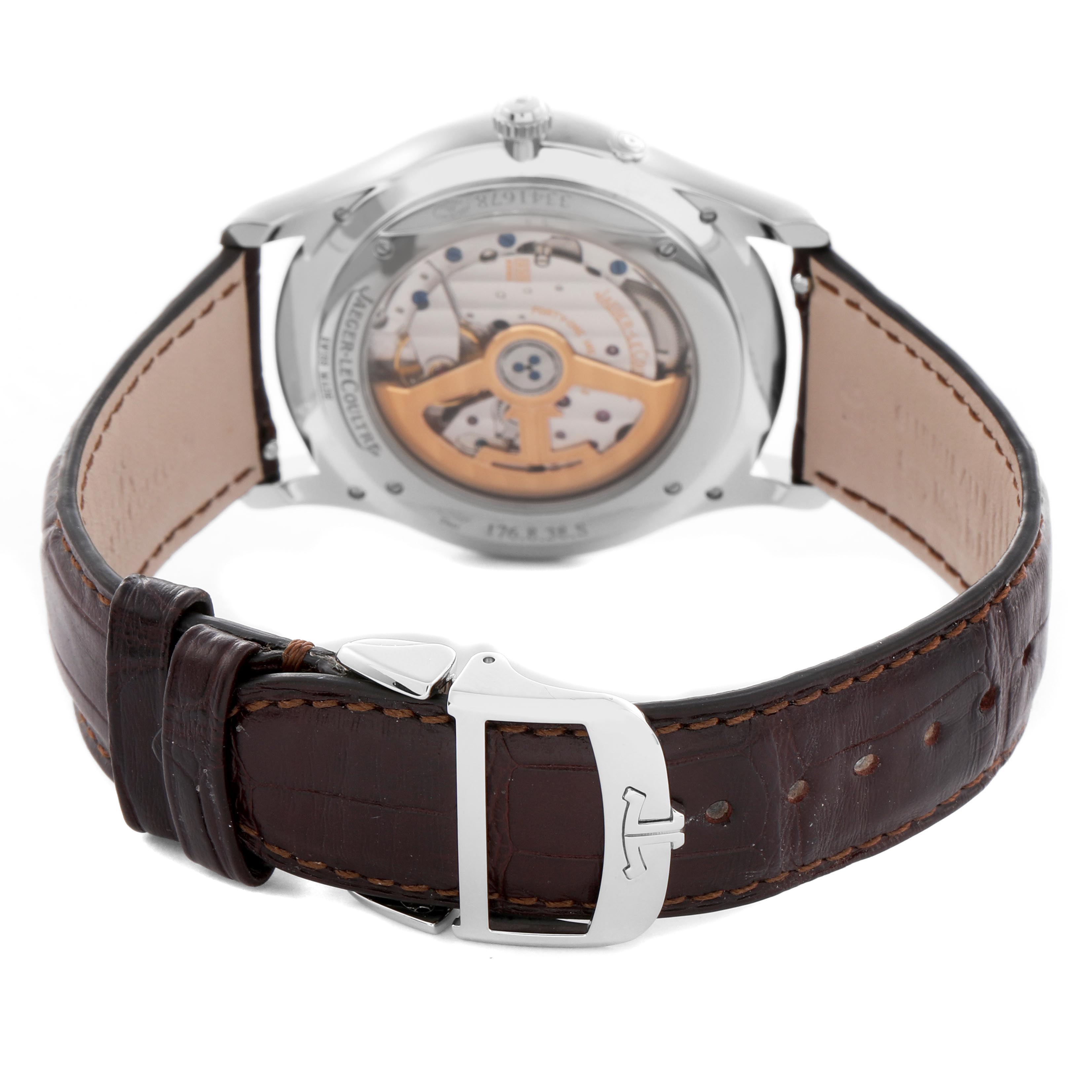 The Jaeger LeCoultre Master Q1378420 Men
s Stainless Steel Silver Dial Q1378420 Men
s Stainless Steel Silver Dial watch is shown from the back, featuring its open case back and brown leather strap with a clasp.