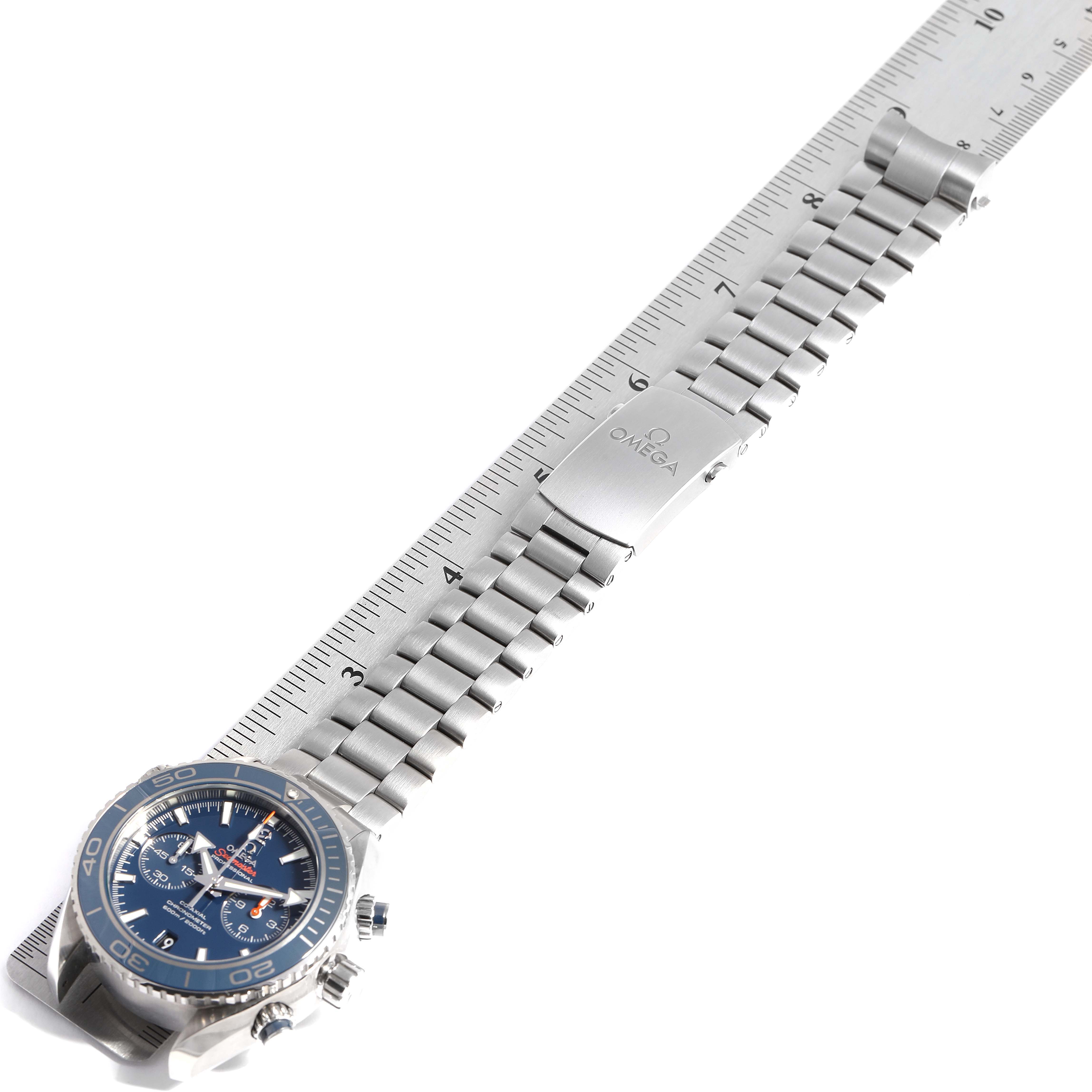 The Omega Planet Ocean 232.90.46.51.03.001 Men's Titanium Blue Dial 232.90.46.51.03.001 Men's Titanium Blue Dial watch is shown from a top-down angle, displaying its face and full metal bracelet against a ruler for scale.