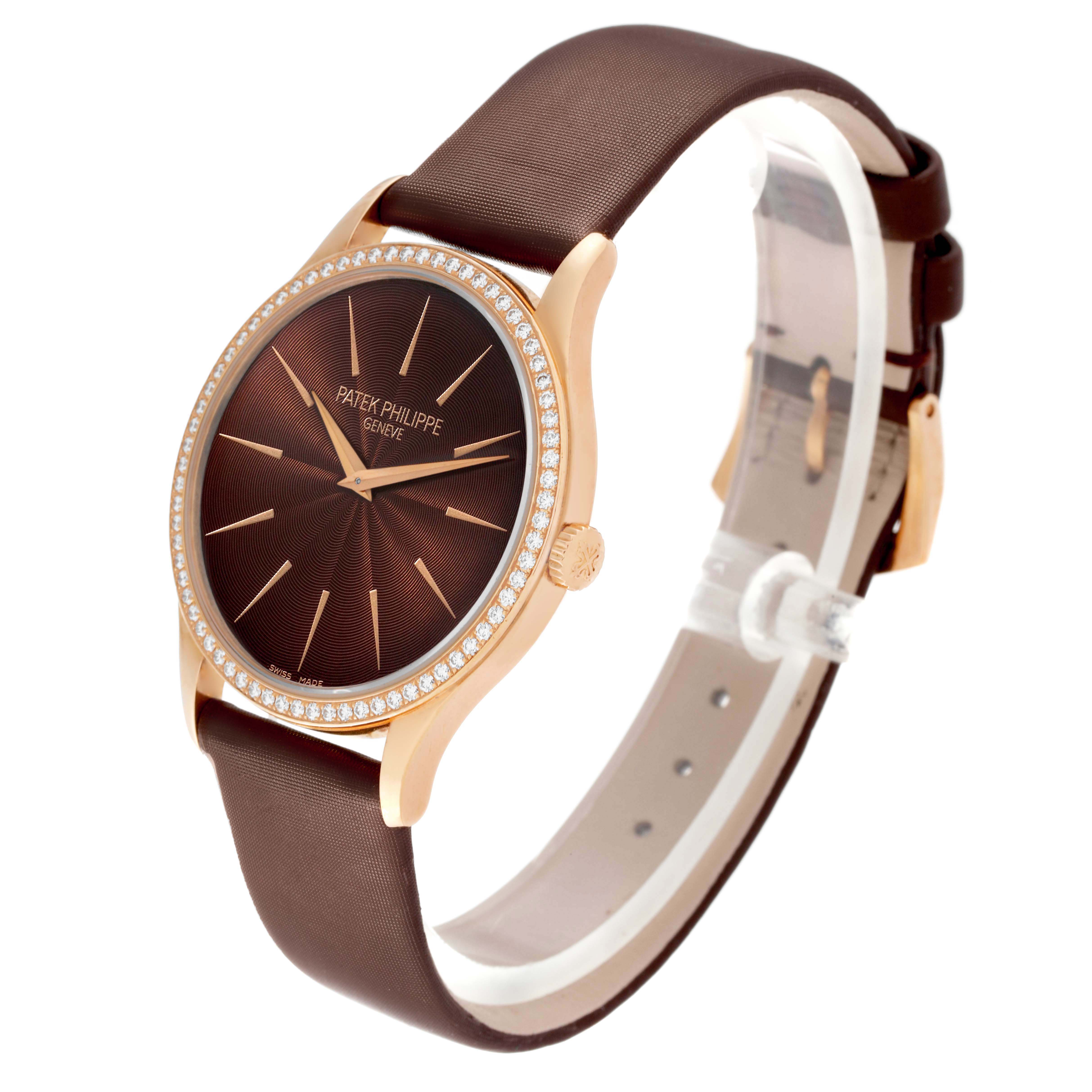 The Patek Philippe Calatrava 4897R-001 Womens Rose Gold Brown Dial watch is shown at a three-quarter angle, highlighting its brown dial, diamond bezel, and leather strap.