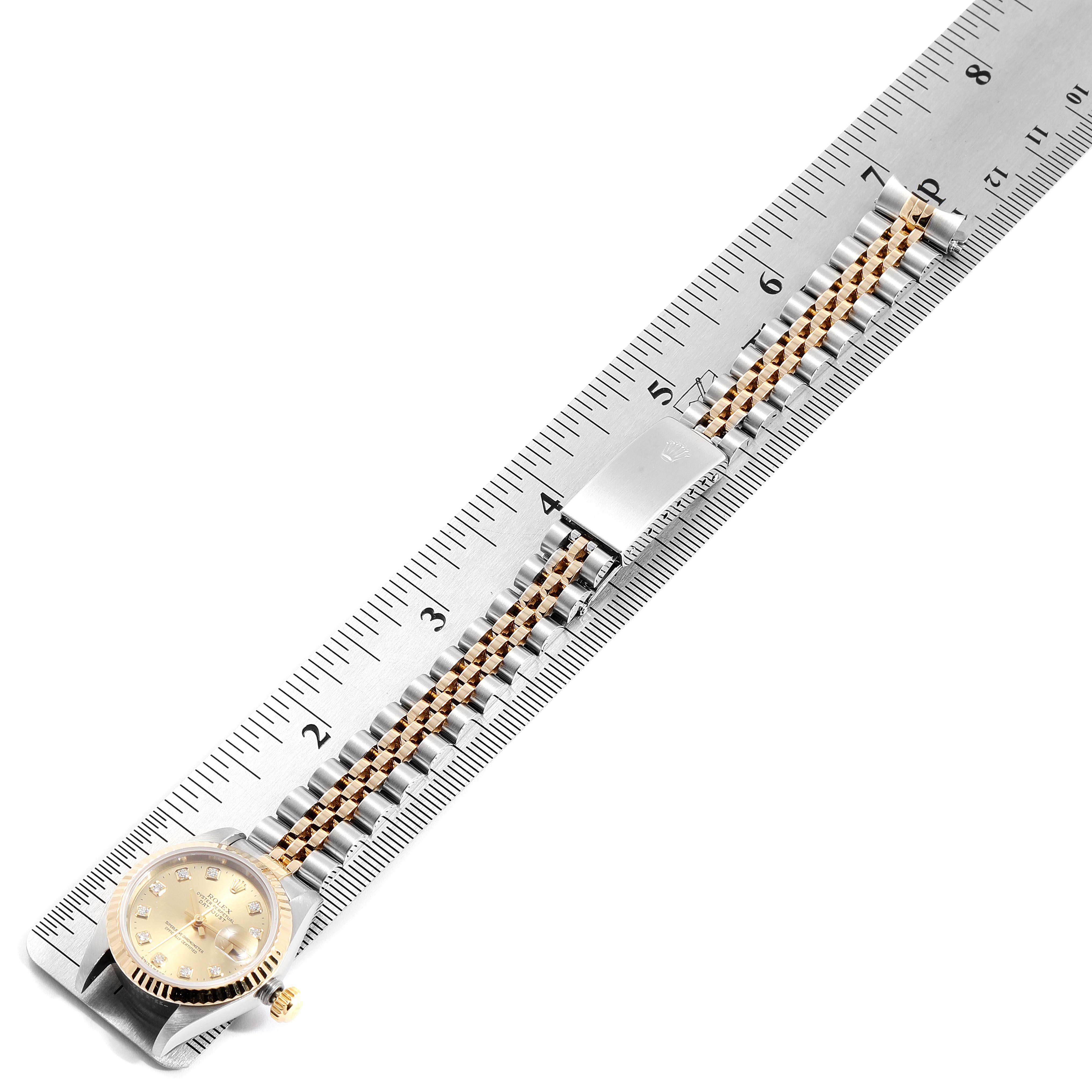 This image shows a Rolex Datejust 69173 Women's Steel and Gold (two tone) Champagne Dial 69173 Women's Steel and Gold (two tone) Champagne Dial watch placed on a ruler, displaying the watch face, crown, and entire bracelet.