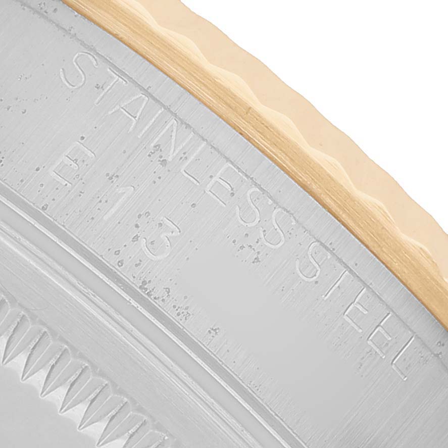 The image shows a close-up of the rehaut and fluted bezel of a Rolex Datejust 16233 Men's Stainless Steel Champagne Dial, highlighting the "STAINLESS STEEL" engraving.