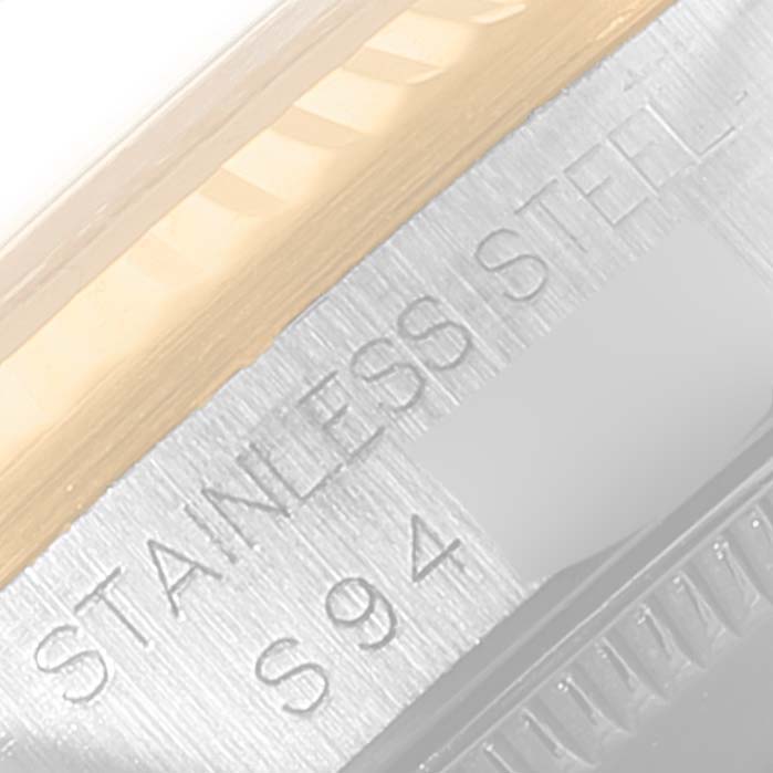 The image shows a close-up of the case back edge and markings on the stainless steel of a Mid-Size Rolex watch.