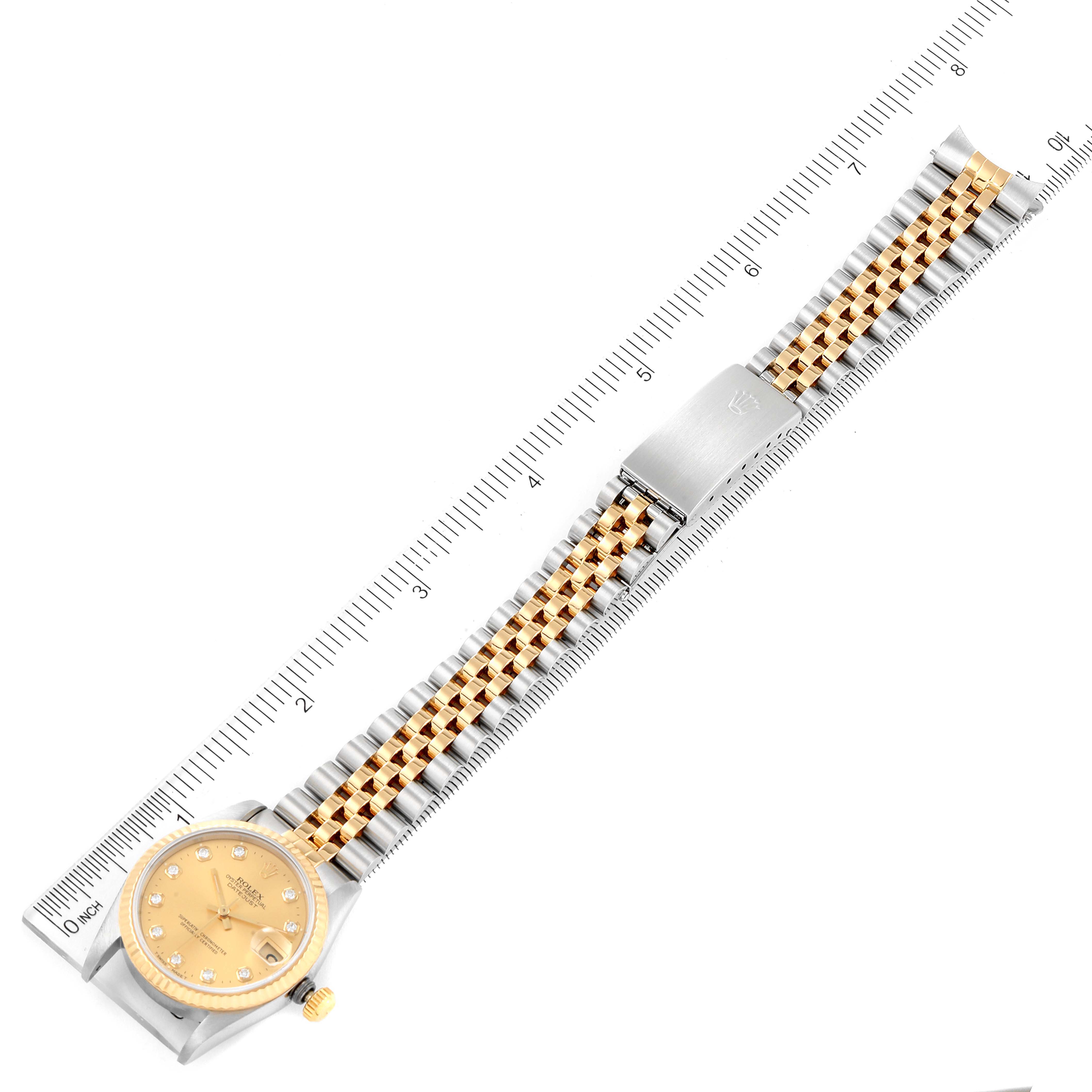 This image shows a Rolex Mid-Size 68273 Women
s Steel and Gold (two tone) Champagne Dial 68273 Women
s Steel and Gold (two tone) Champagne Dial watch with a gold face and a two-tone metal bracelet, laid flat with a ruler for scale.