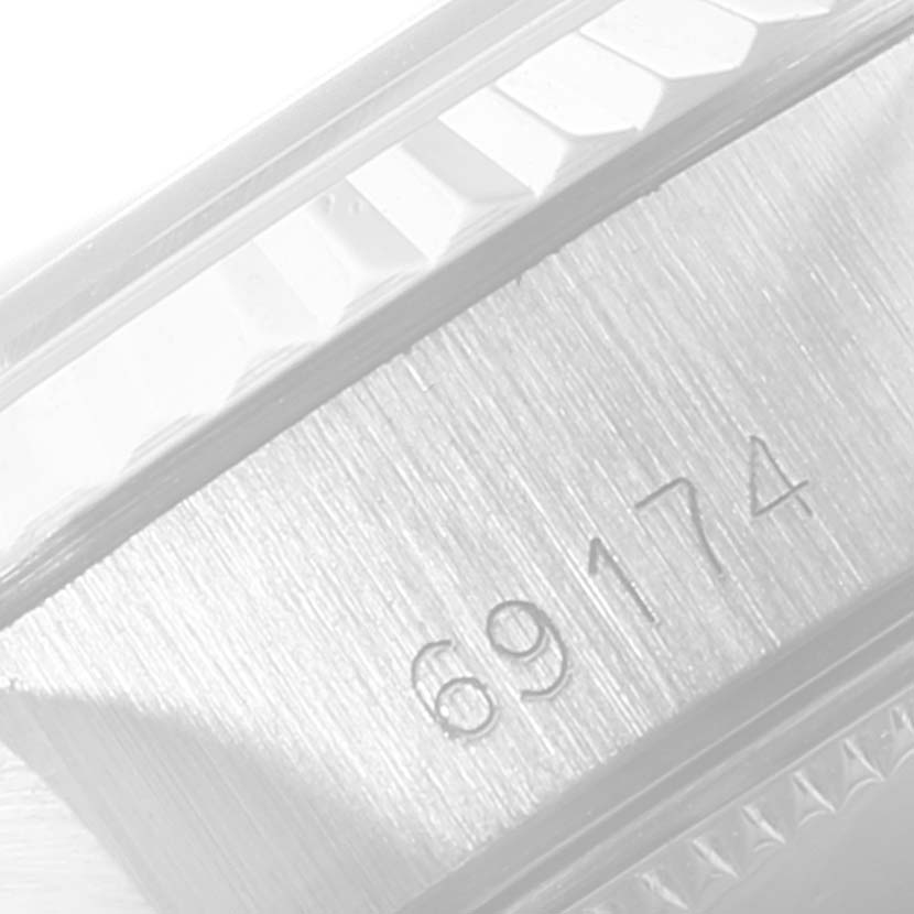 The image shows a close-up of the side of a Rolex Datejust 69174 Women
s Stainless Steel Silver Dial 69174 Women
s Stainless Steel Silver Dial model, focusing on the fluted bezel and reference number 69174.