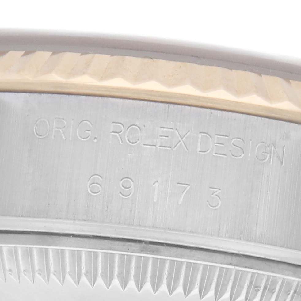 The image shows a close-up of the side of the Rolex Datejust 69173 Women's Steel and Gold (two tone) Champagne Dial 69173 Women's Steel and Gold (two tone) Champagne Dial case, featuring the engraving "ORIG. ROLEX DESIGN" and the reference number.