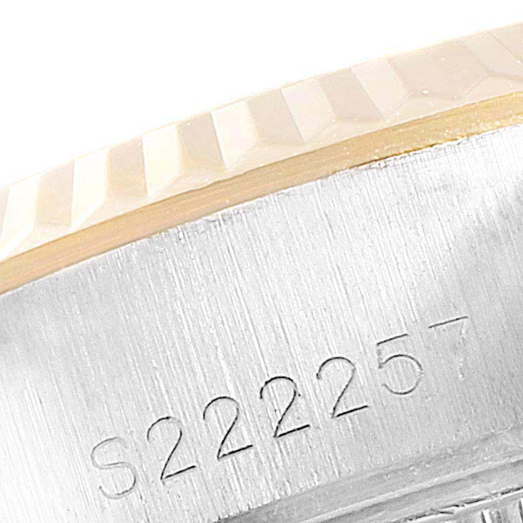 The image shows a close-up of the case and fluted bezel of a Rolex Datejust 69173 Women
s Steel and Gold (two tone) Champagne Dial 69173 Women
s Steel and Gold (two tone) Champagne Dial watch, focusing on the serial number.
