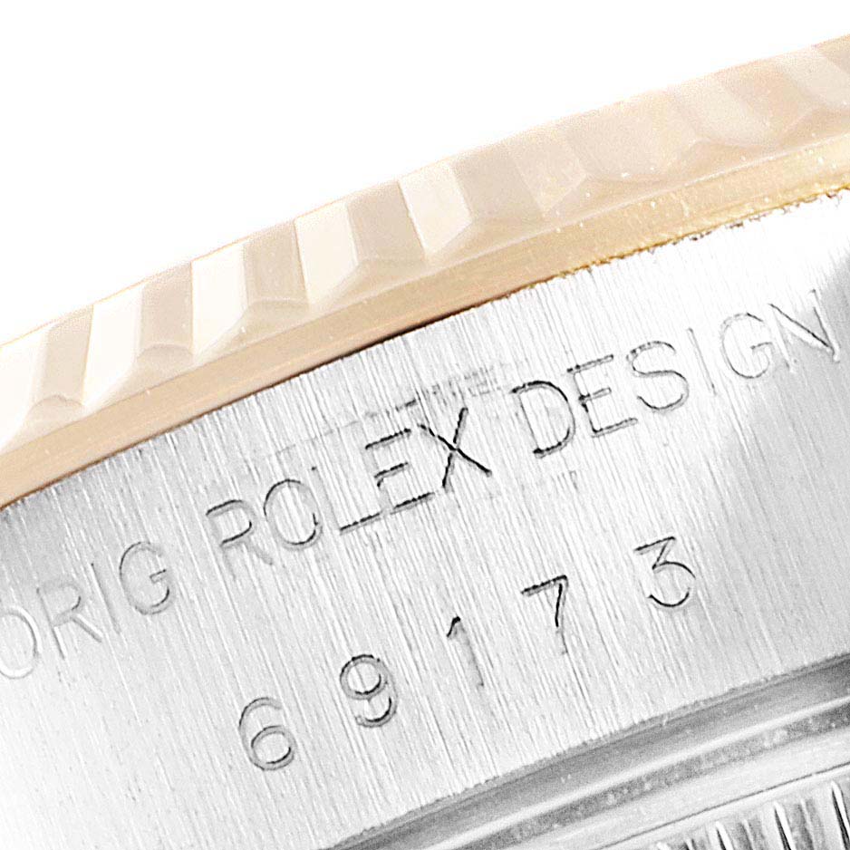 This image shows a close-up of the side of the bezel and case with engravings on a Rolex Datejust 69173 Women
s Steel and Gold (two tone) White Dial 69173 Women
s Steel and Gold (two tone) White Dial watch.